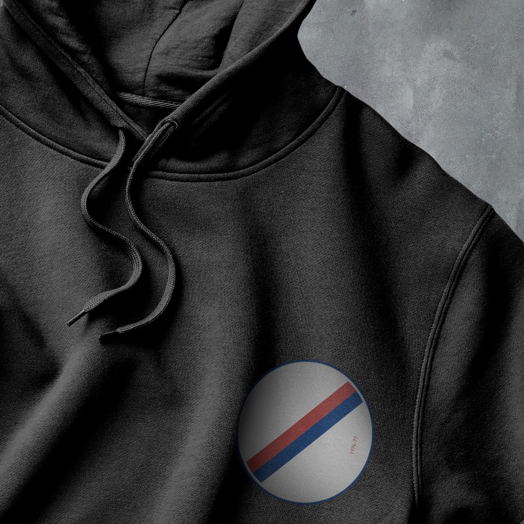 a black hoodie with a red, white, and blue stripe on it