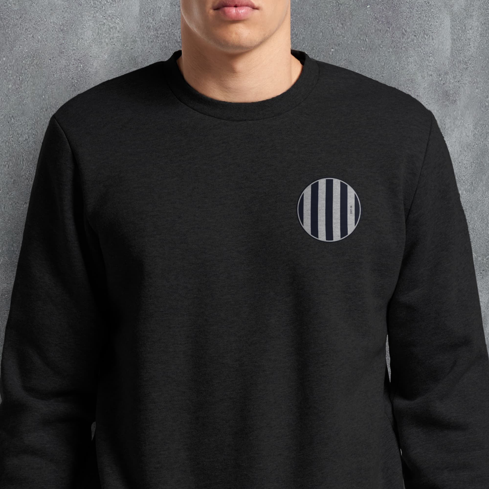 a man wearing a black sweatshirt with a striped pocket