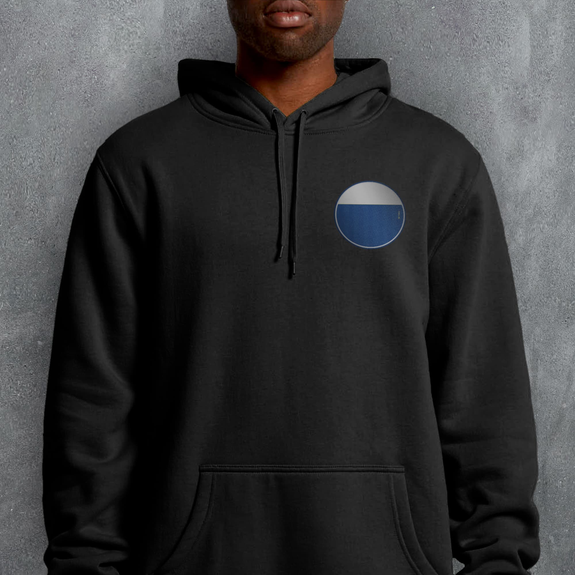 a man wearing a black hoodie with a blue circle on it