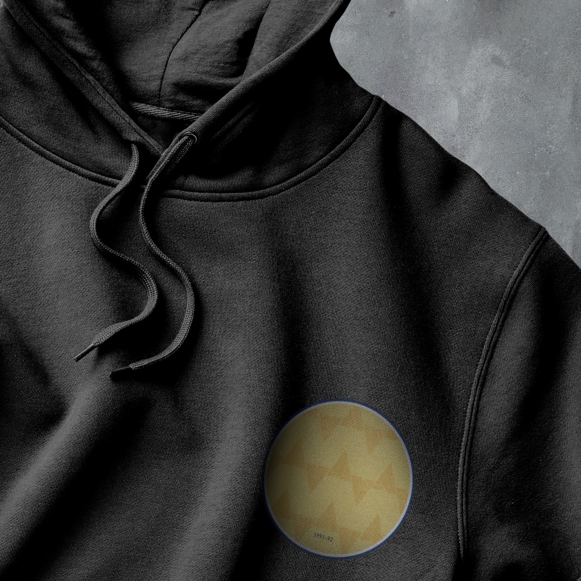 a black hoodie with a yellow circle on it