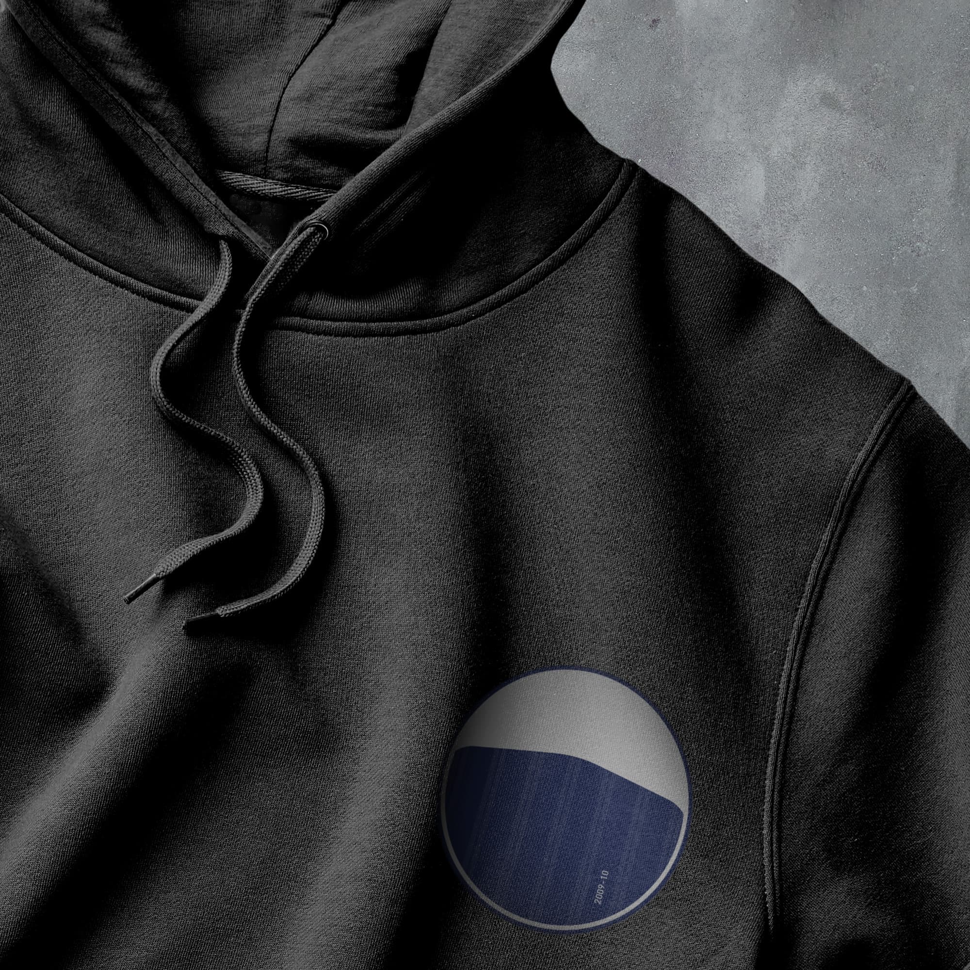 a black hoodie with a blue and white circle on it