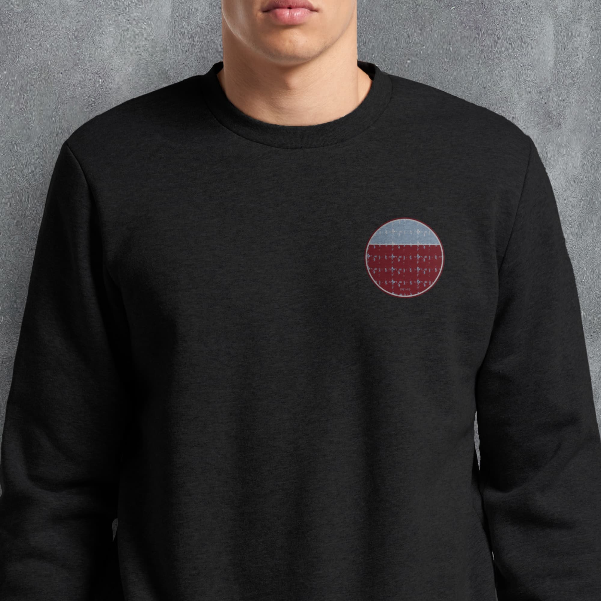 a man wearing a black sweatshirt with a red circle on it