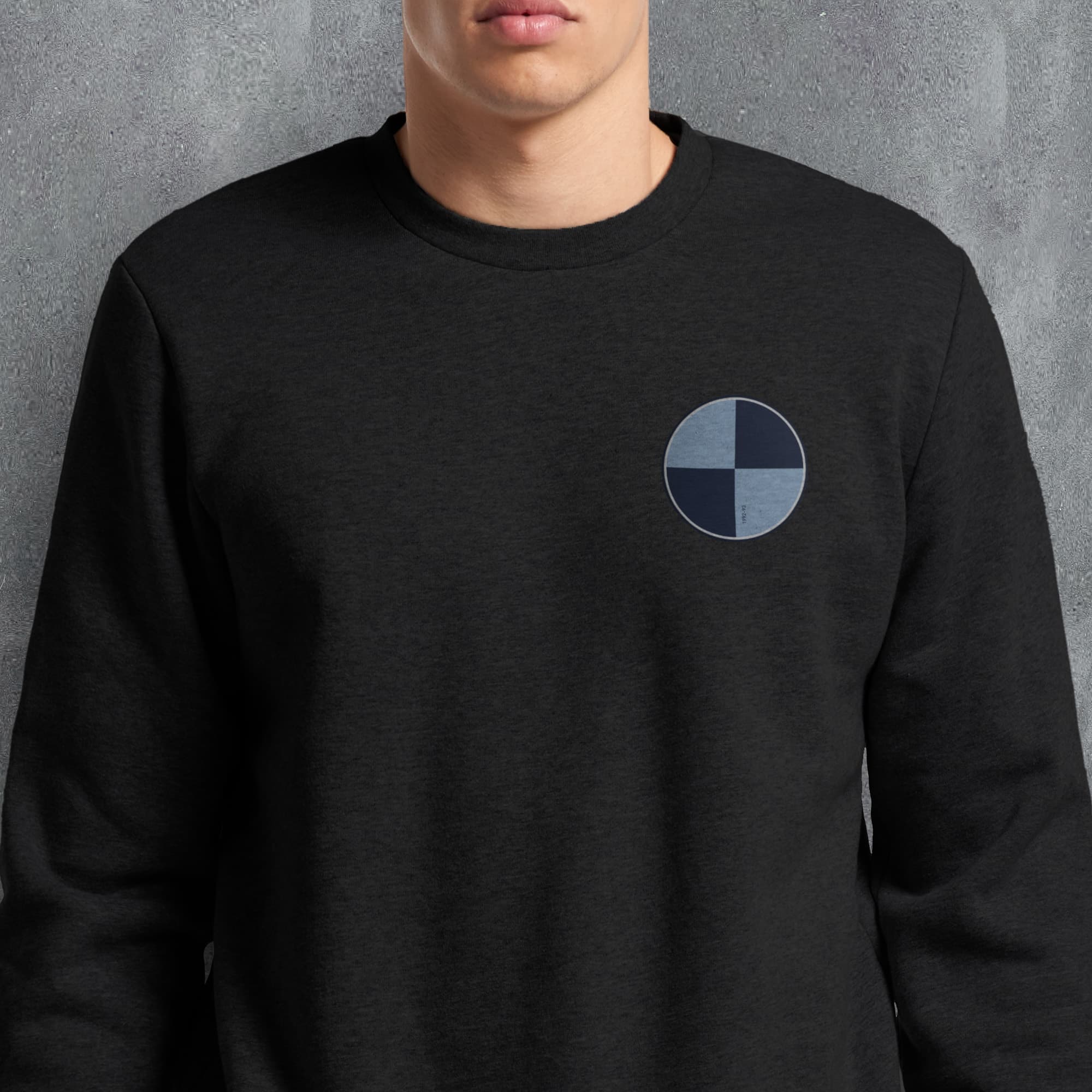 a man wearing a black sweatshirt with a blue circle on it