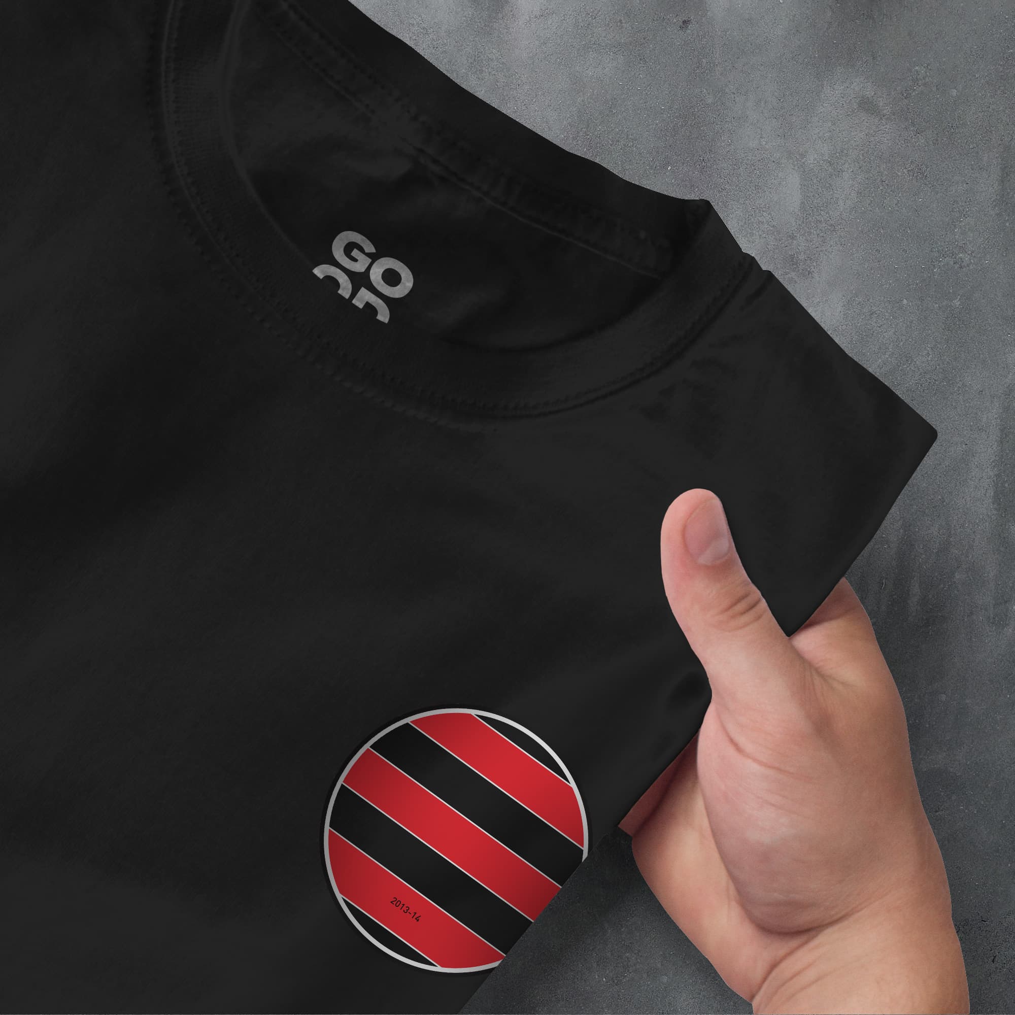 a hand pointing at a black shirt with red and black stripes