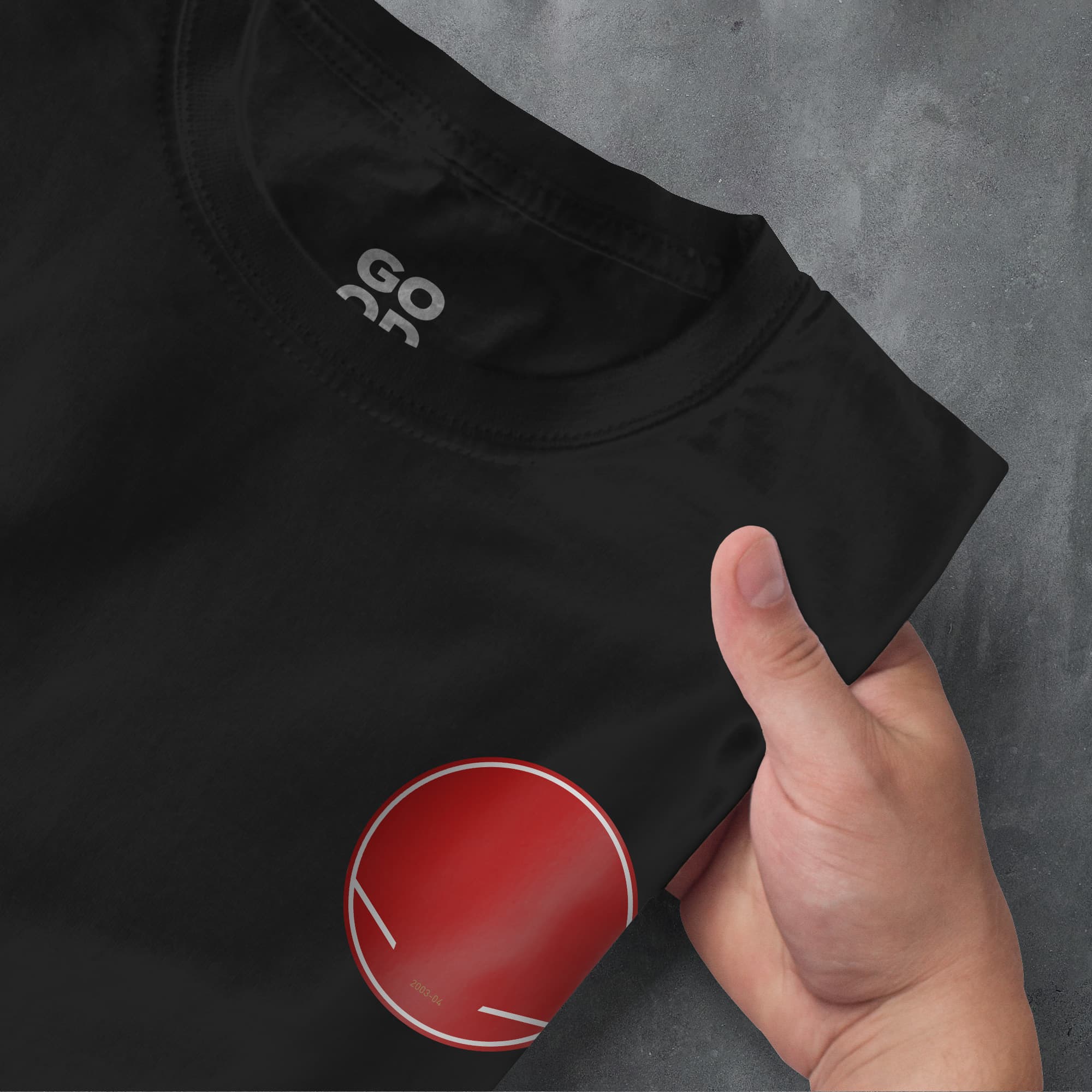 a person's hand pointing at a t - shirt with the word go as