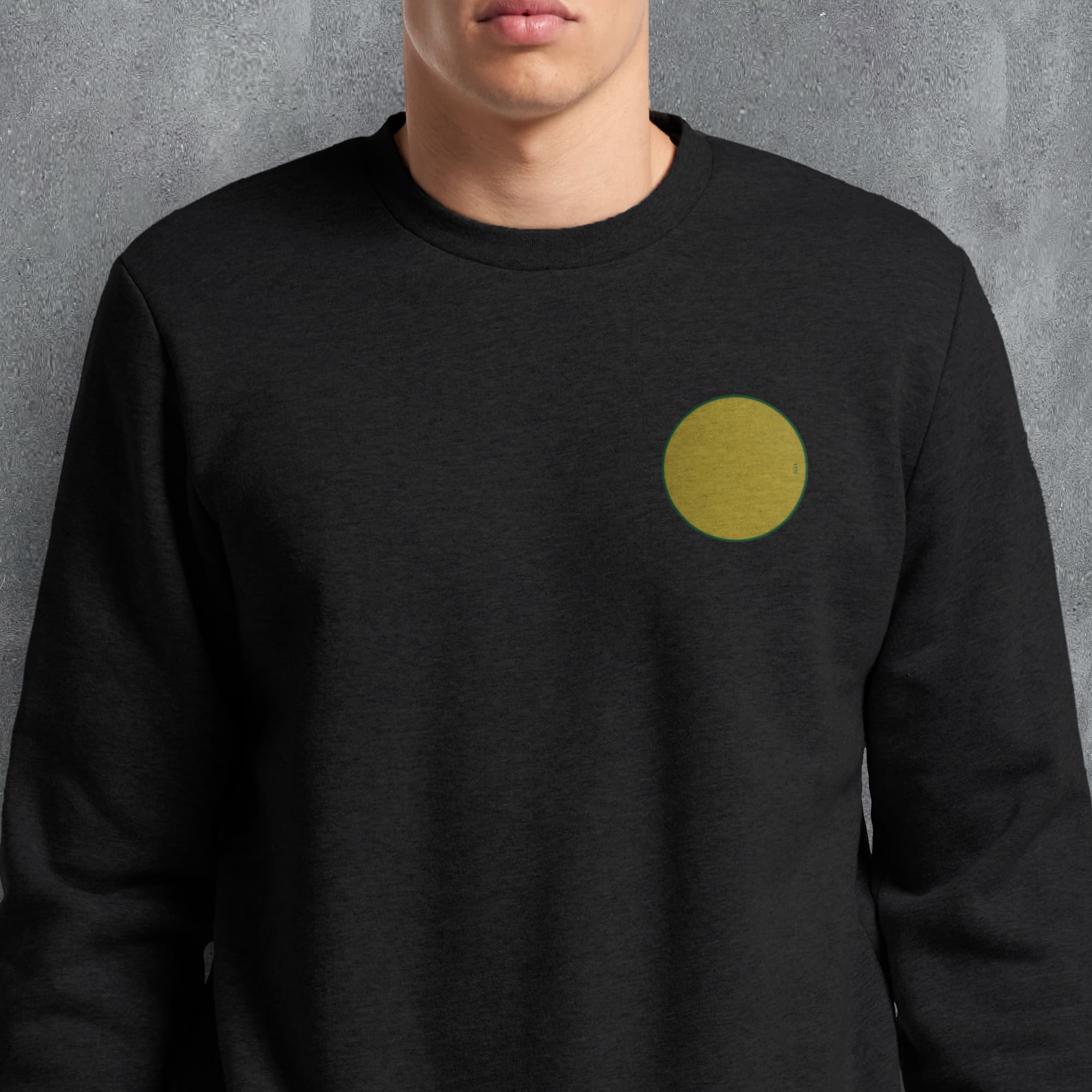 a man wearing a black sweatshirt with a yellow dot on it