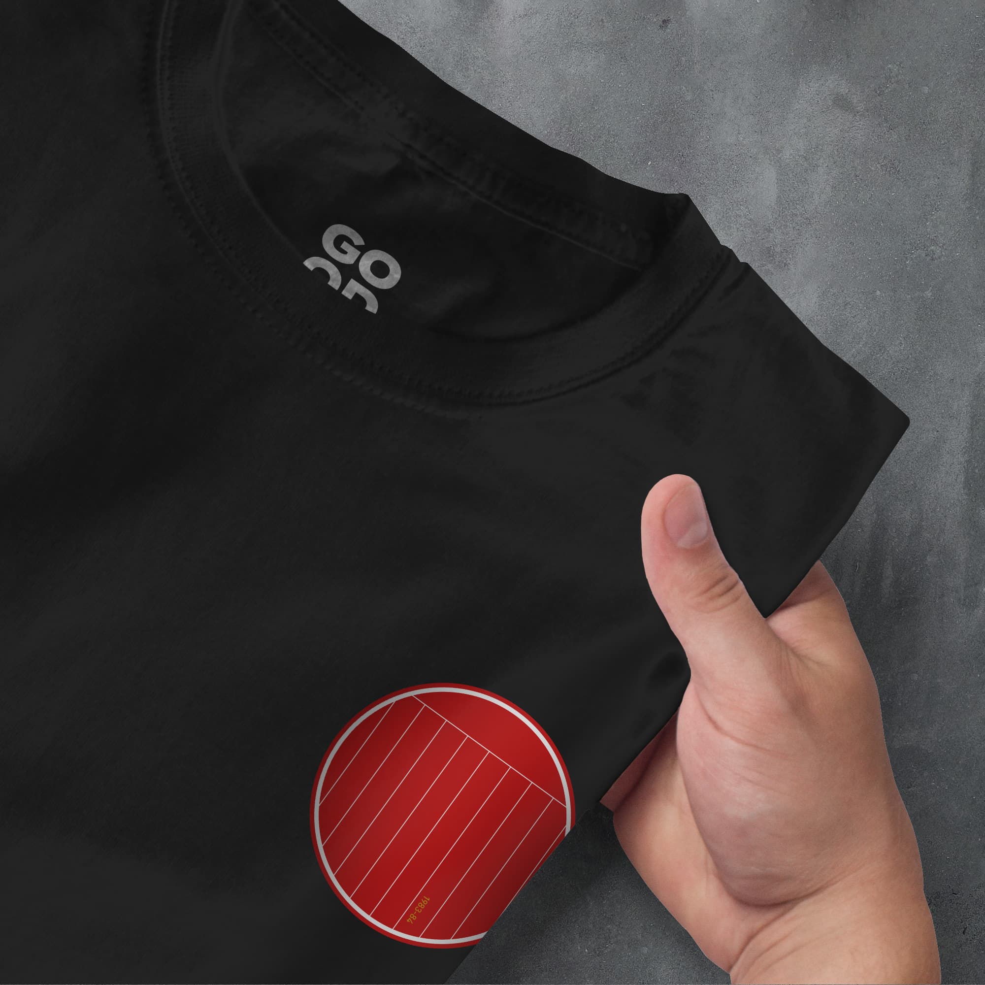 a hand pointing at a black shirt with a red circle on it
