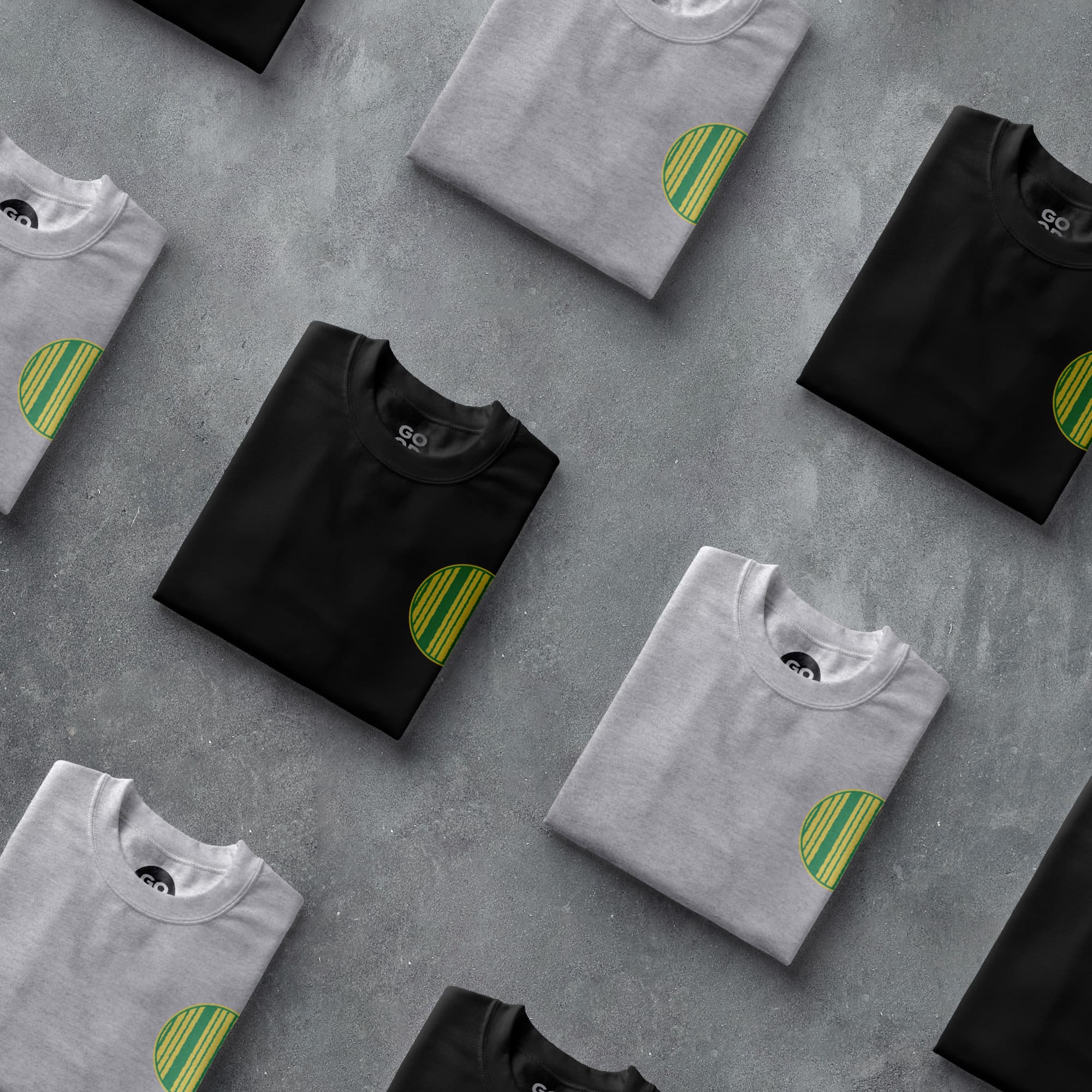 a group of black and white t - shirts sitting on top of a cement floor