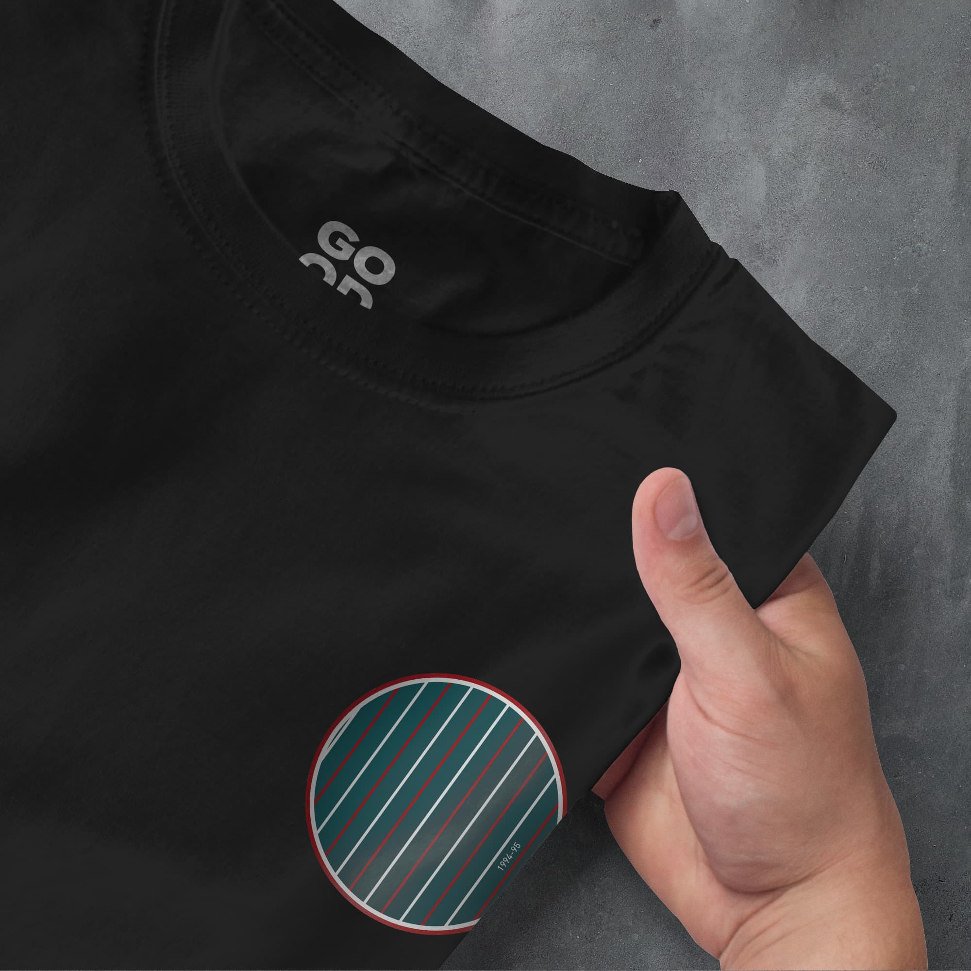 a person pointing at a black shirt with a green stripe on it