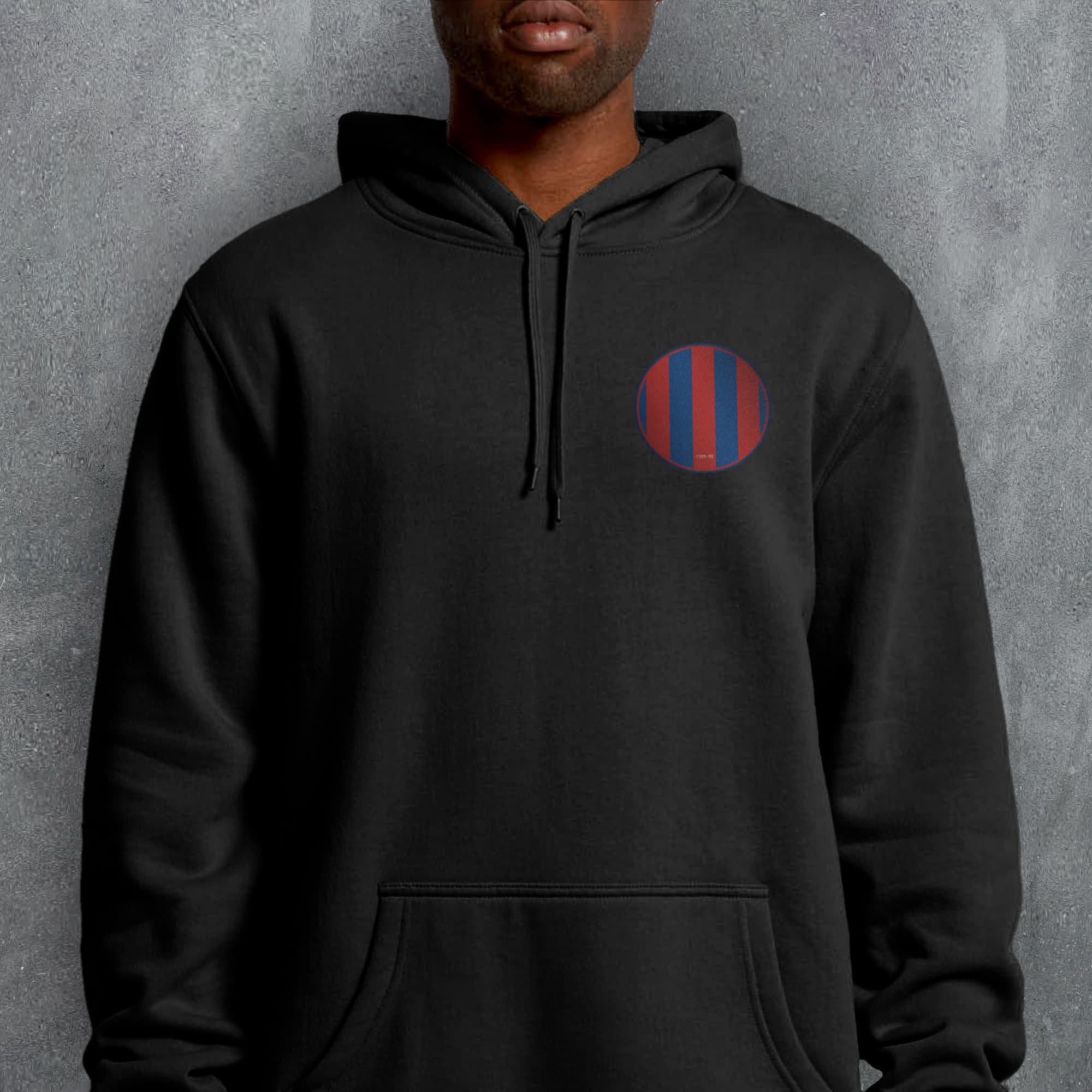 a man wearing a black hoodie with a red and blue circle on it