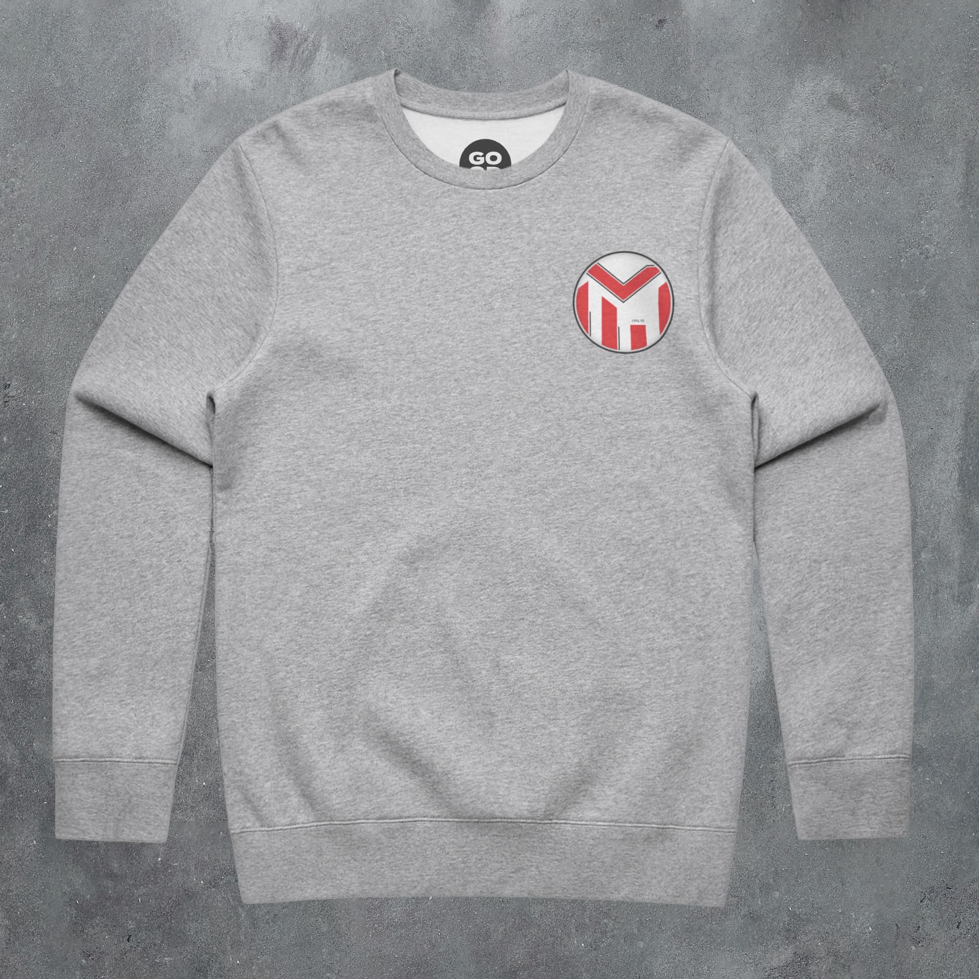 a grey sweatshirt with a red and white m patch