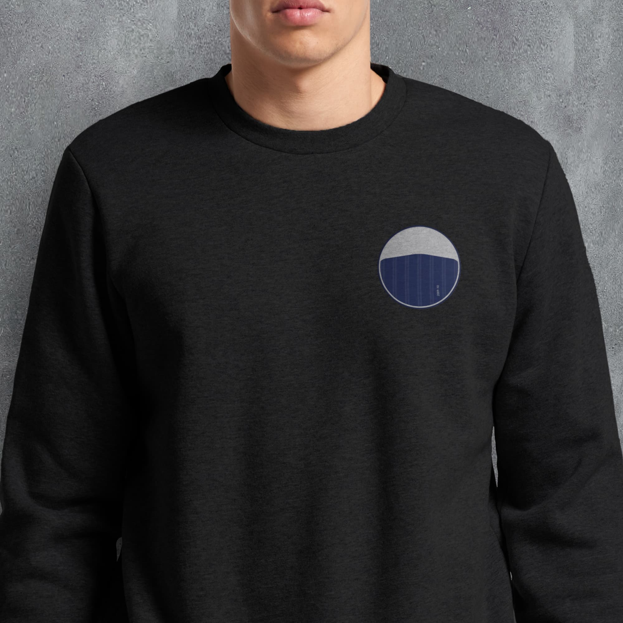 a man wearing a black sweatshirt with a blue circle on it