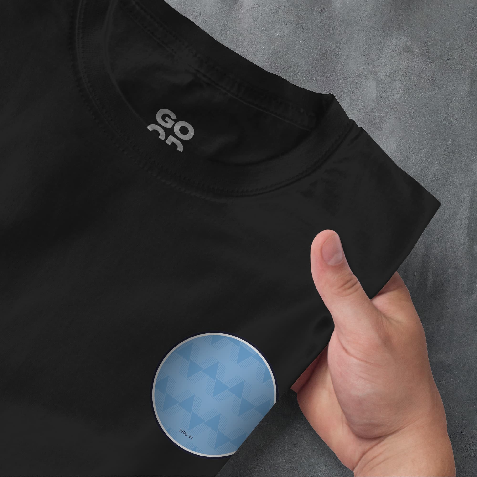 a person's hand pointing at a t - shirt with the word go as