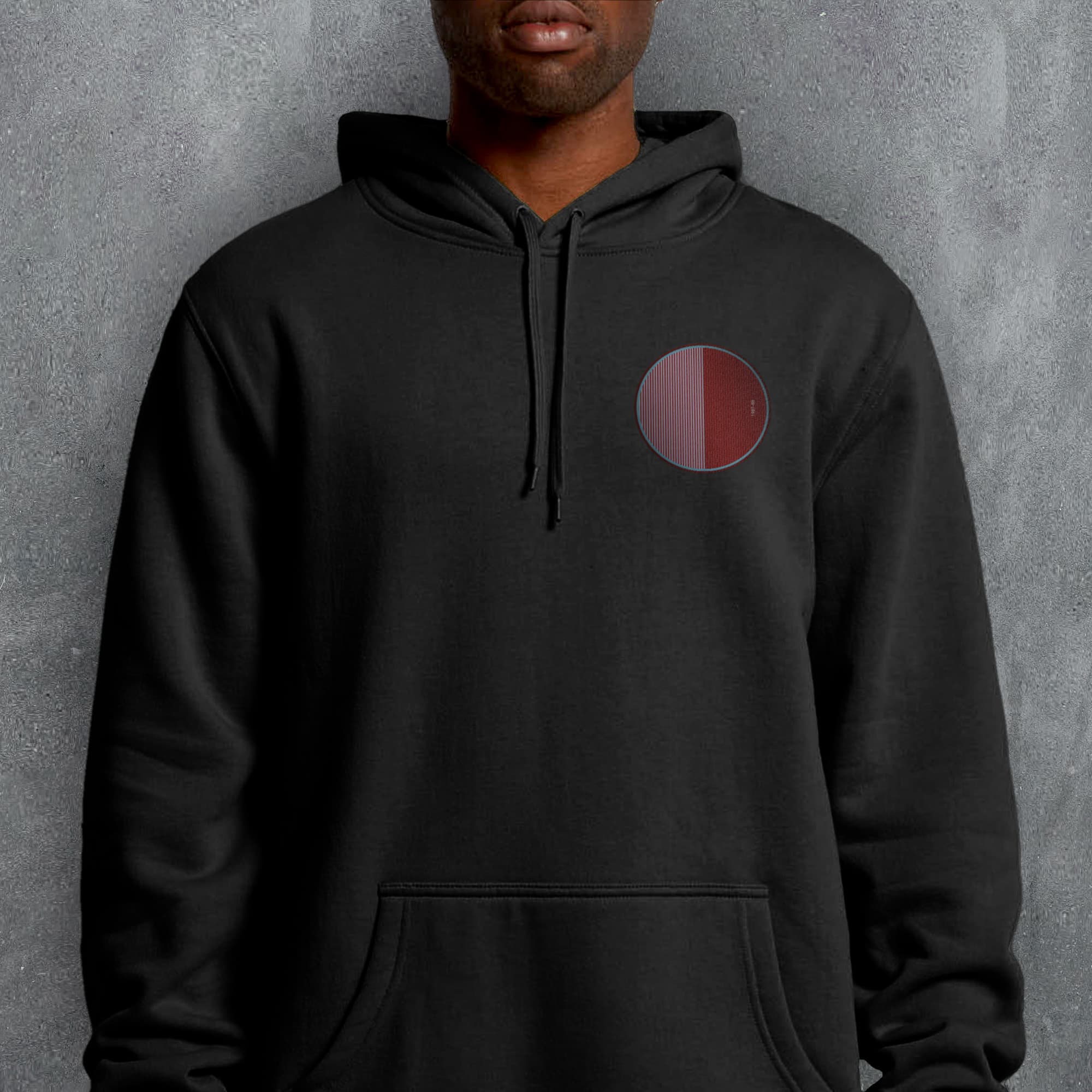 a man wearing a black hoodie with a red circle on it