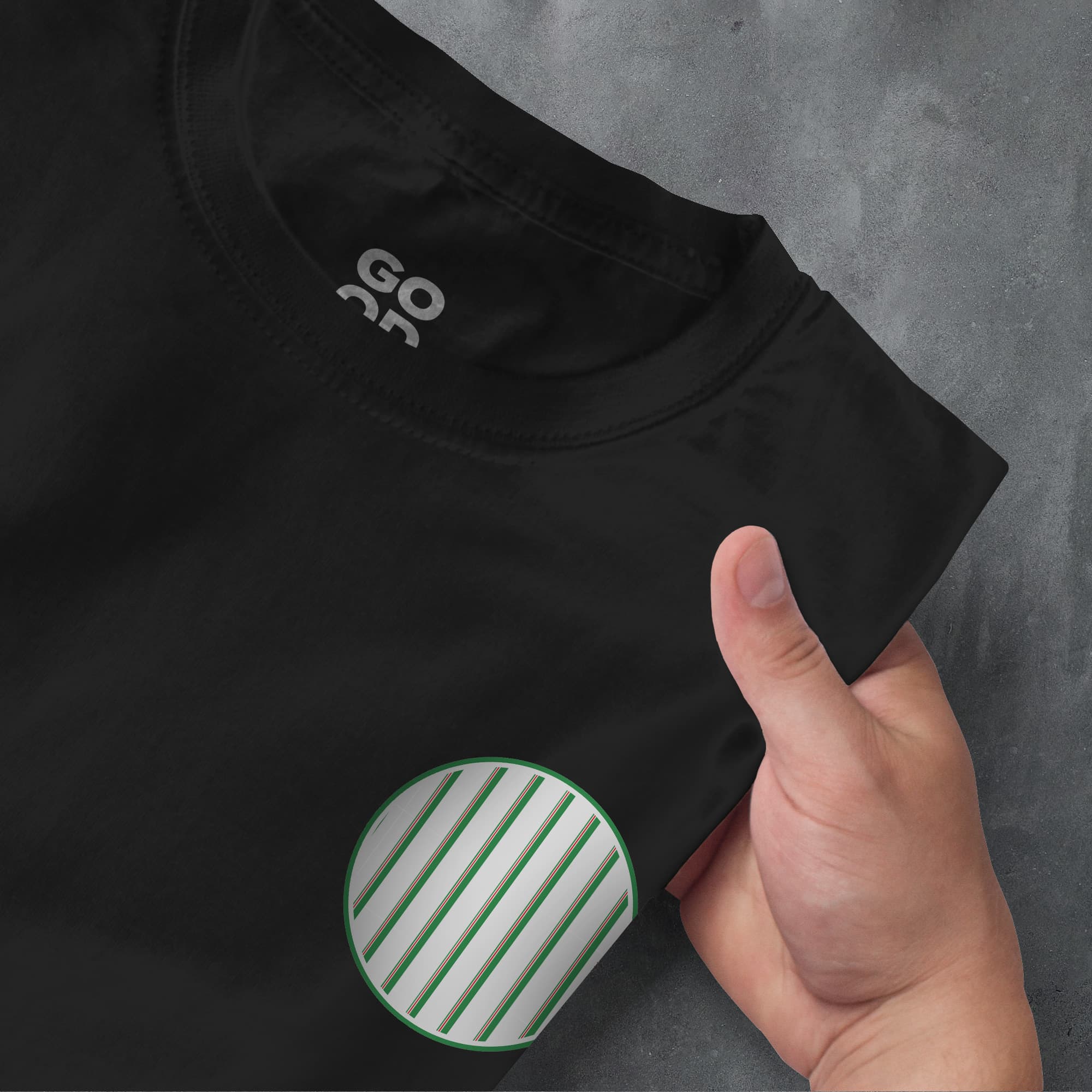 a person pointing at a black shirt with a green stripe on it