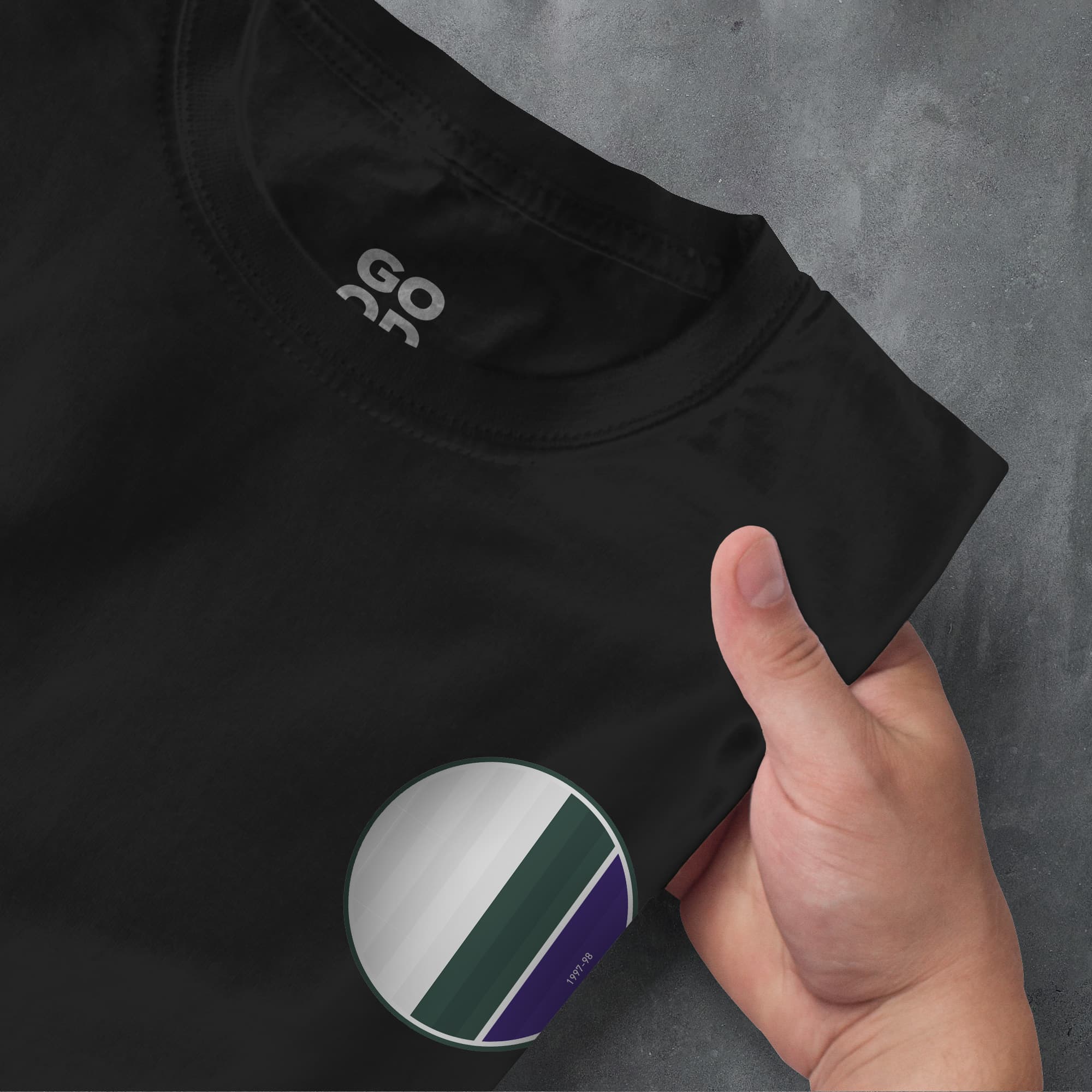 a hand pointing at a black shirt with a green and white stripe