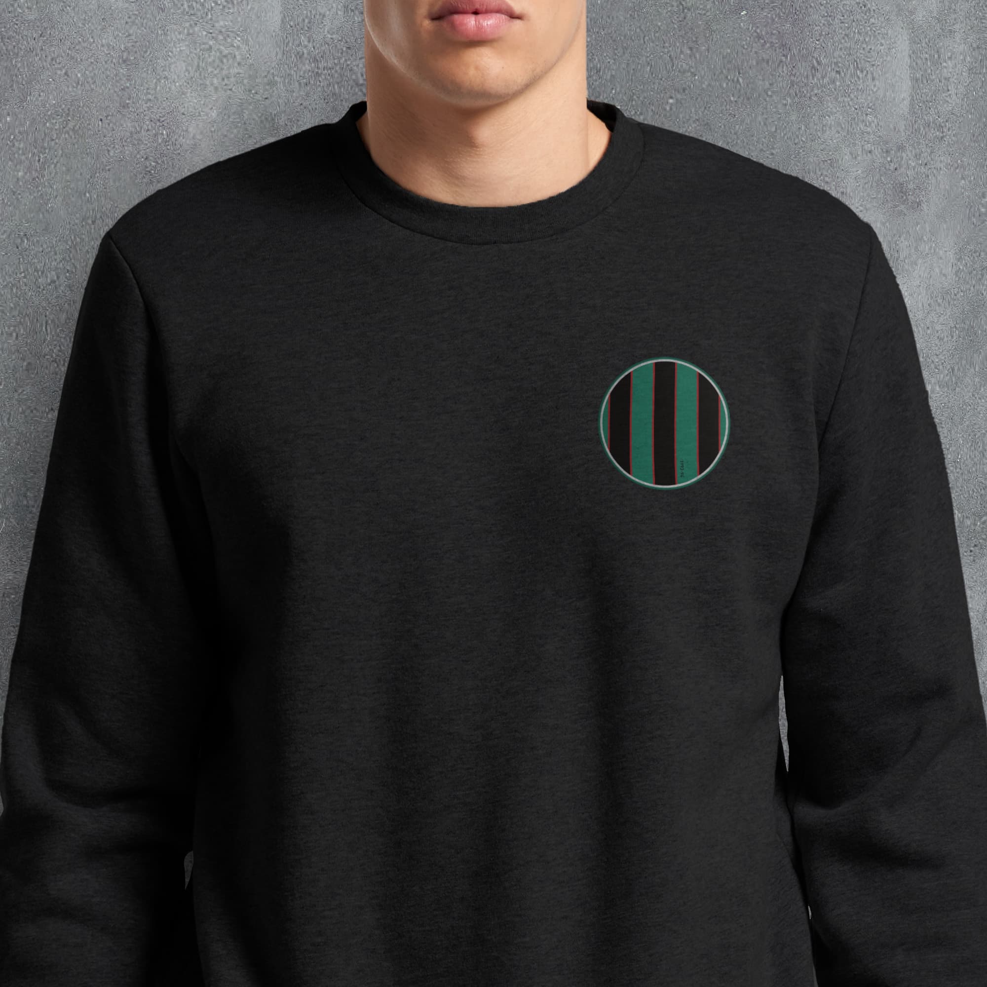 a man wearing a black sweatshirt with a green circle on it