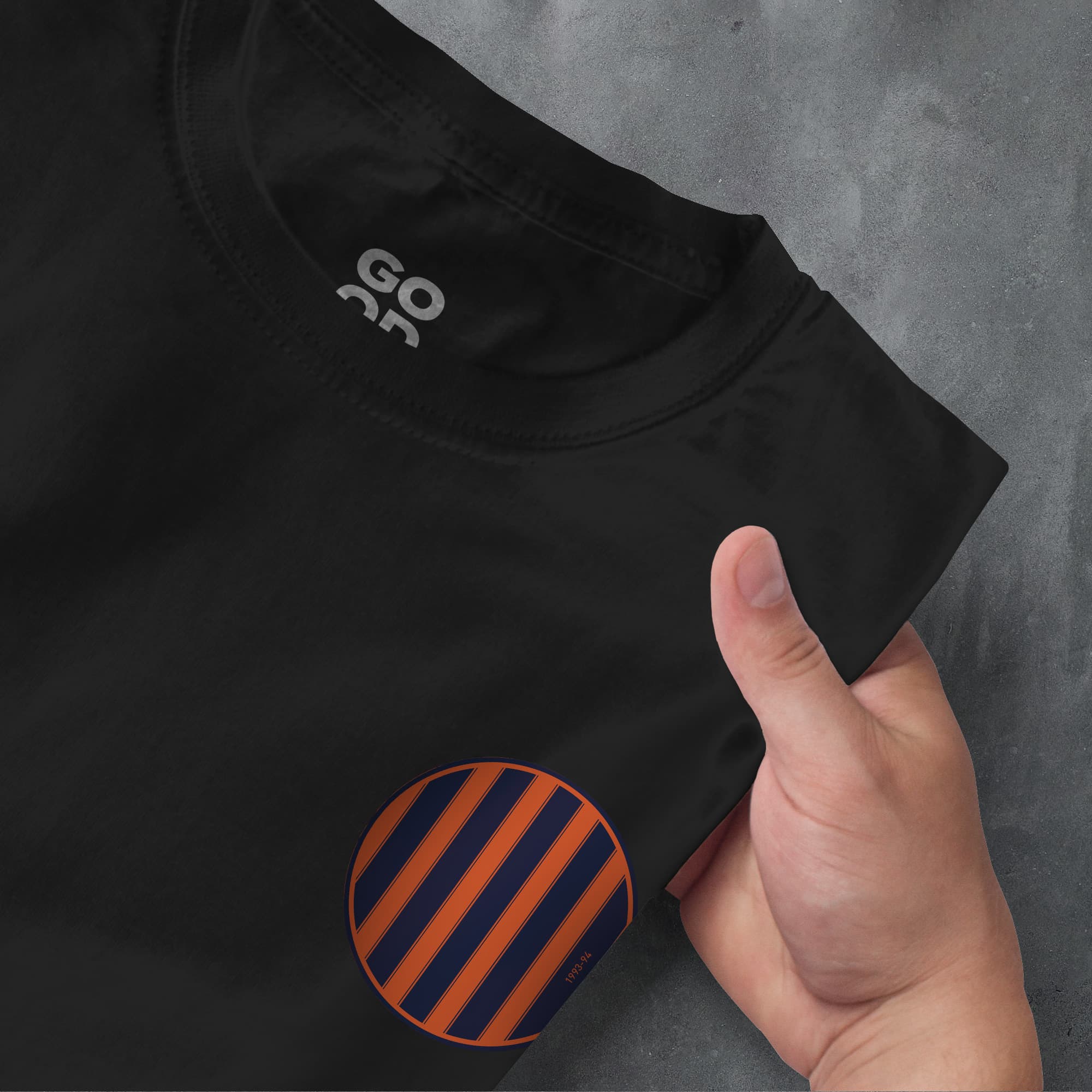 a person pointing at a black shirt with orange and blue stripes