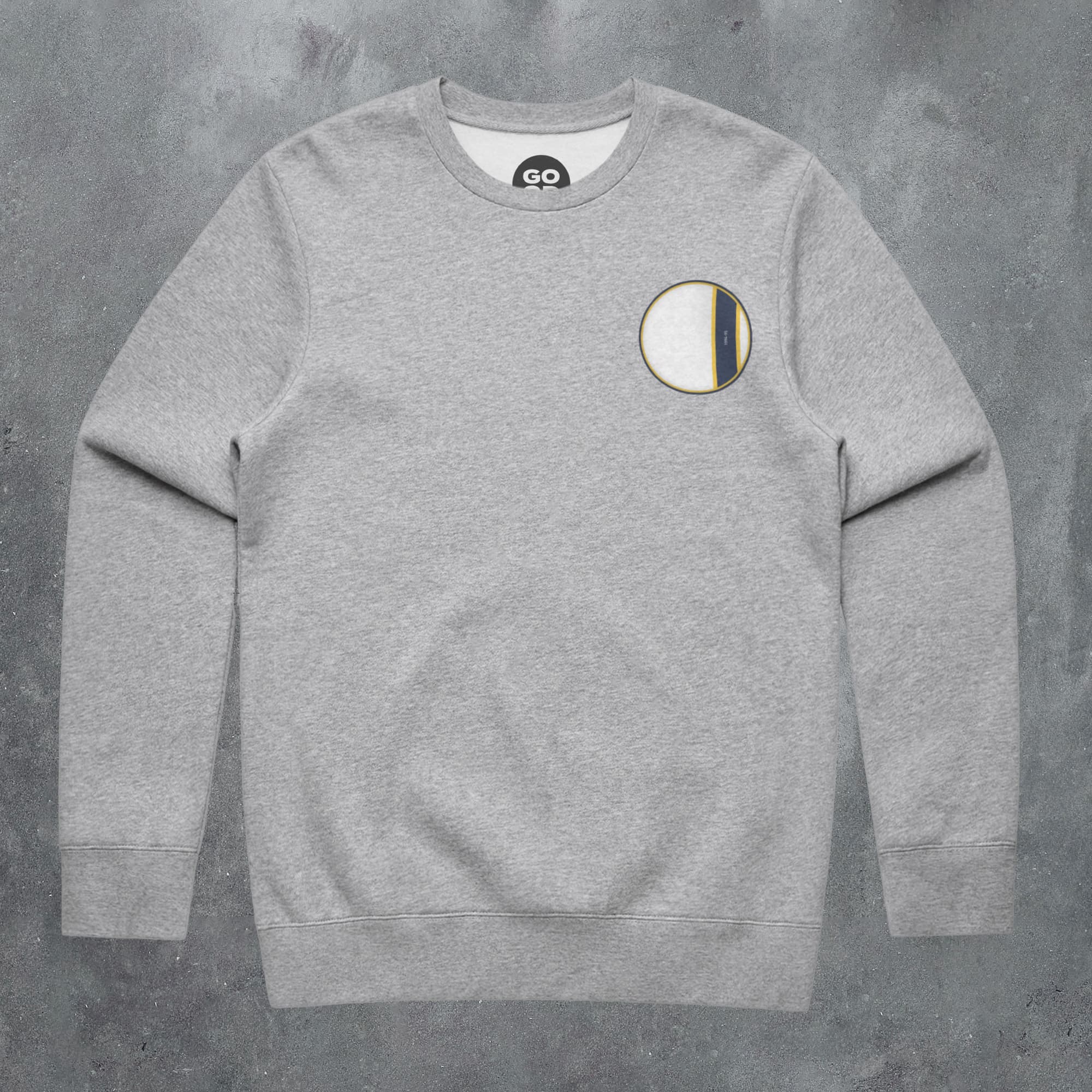 a grey sweatshirt with a white and yellow patch on the chest