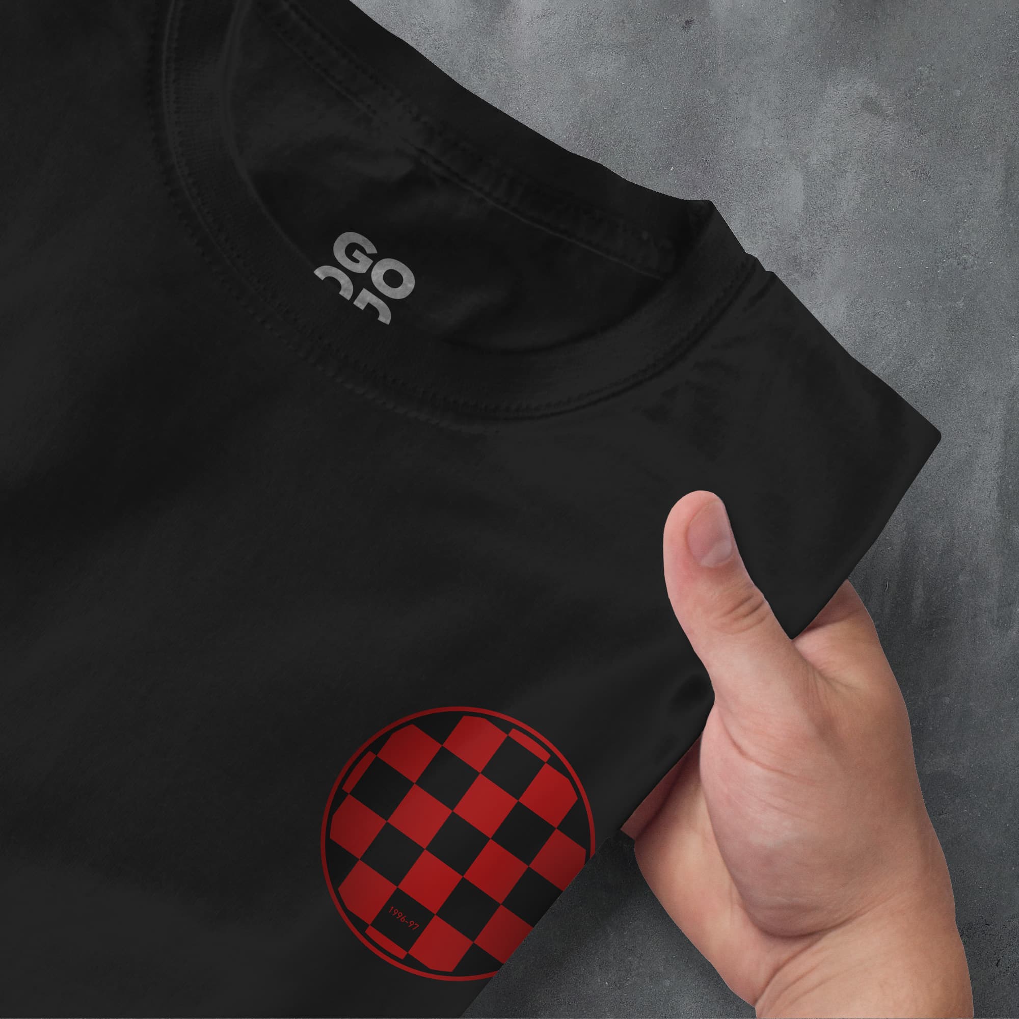 a hand pointing at a black and red shirt
