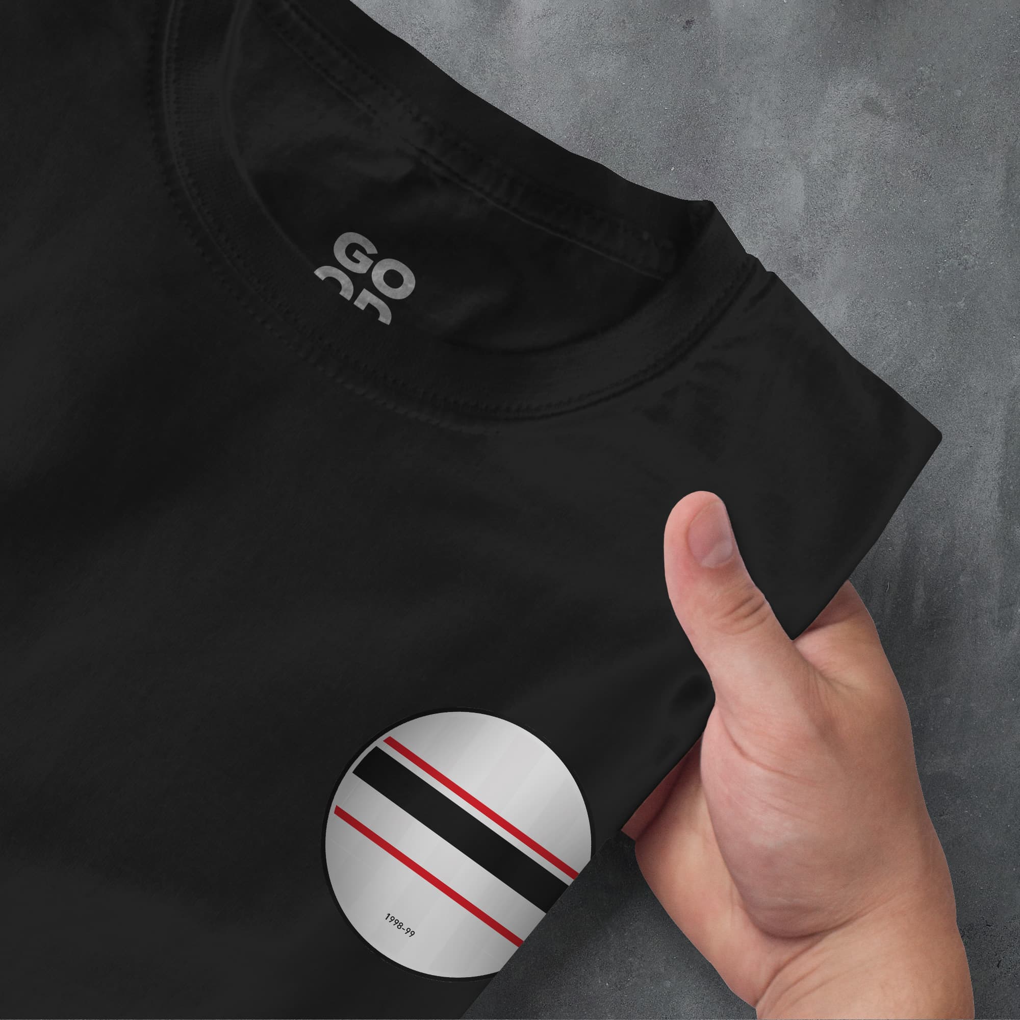 a person holding a black shirt with a red and white stripe on it
