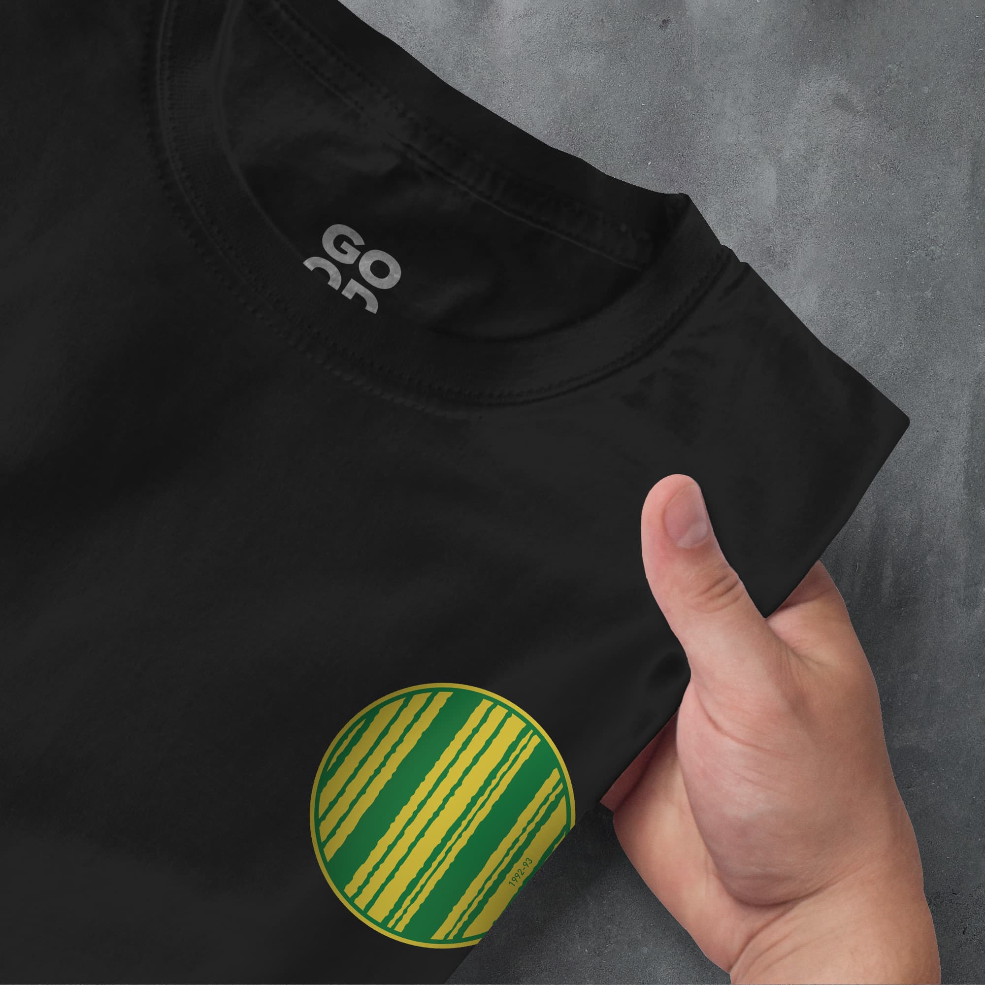 a person pointing at a black shirt with green and yellow stripes