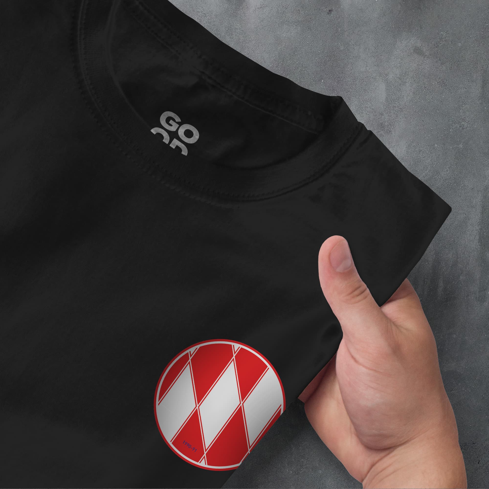 a hand pointing at a red and white shirt