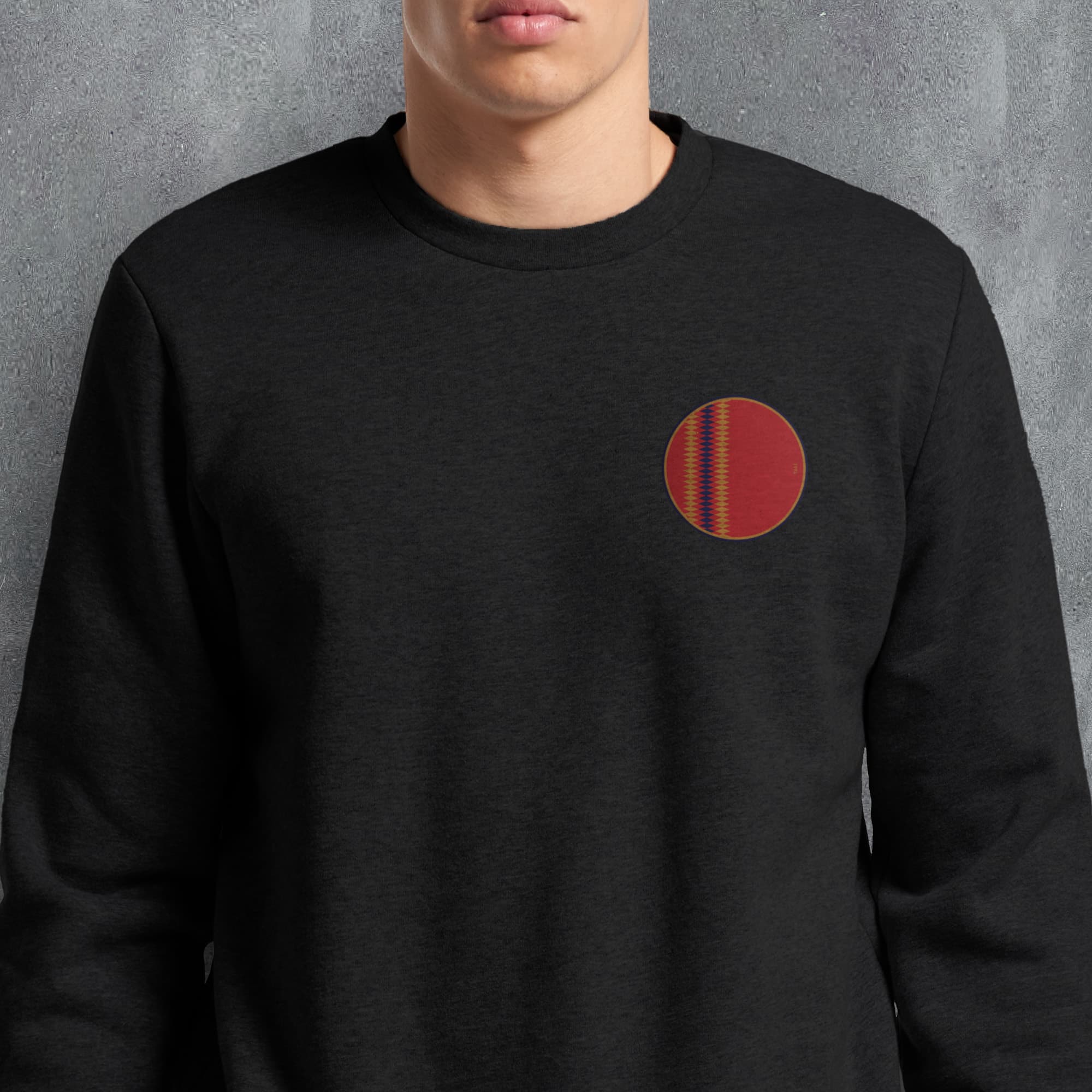 a man wearing a black sweater with a red circle on it