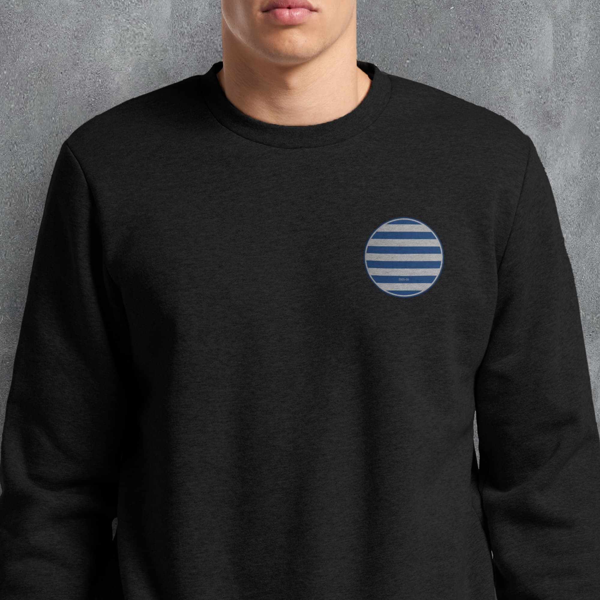 a man wearing a black sweatshirt with a blue and white circle on it