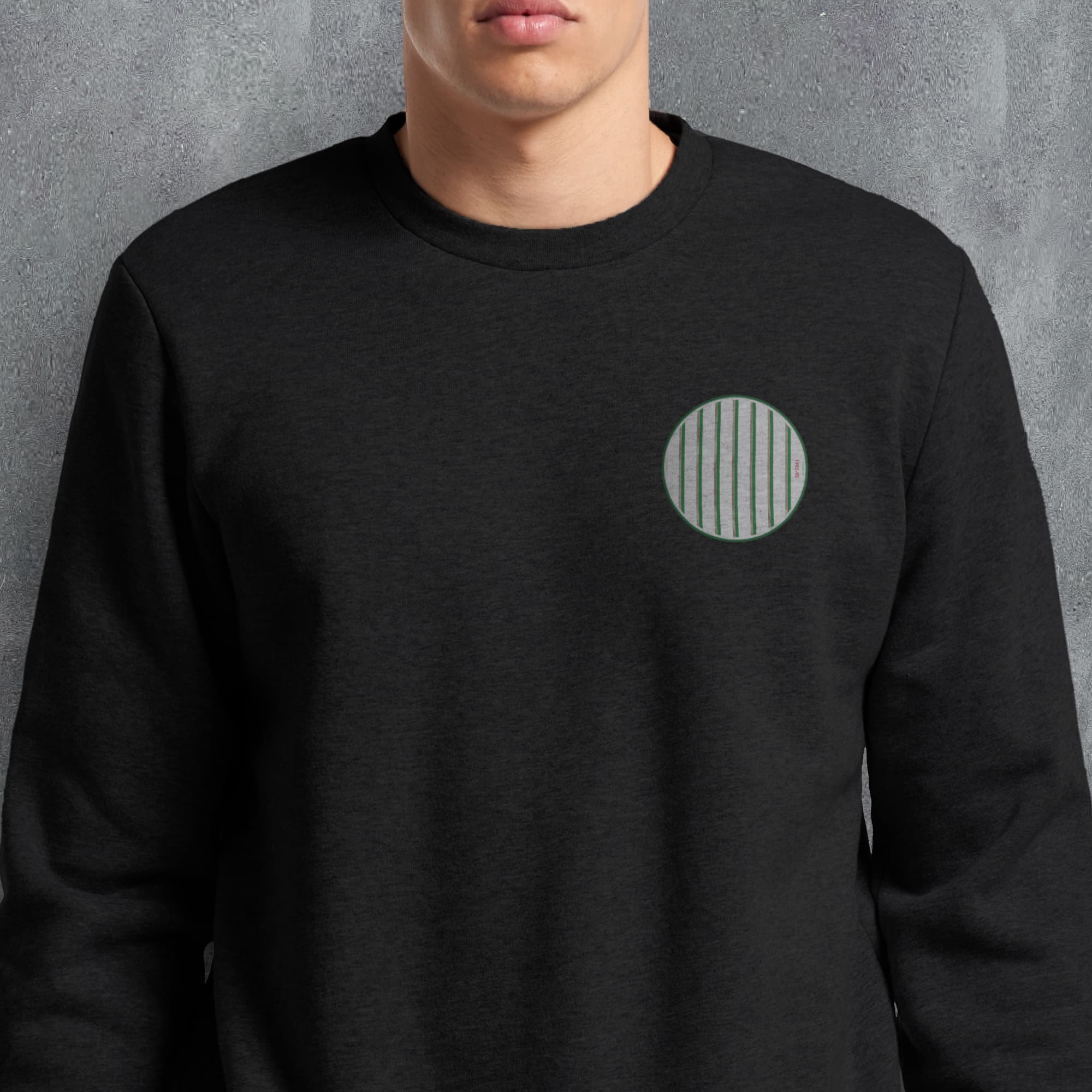 a man wearing a black sweatshirt with a green circle on it