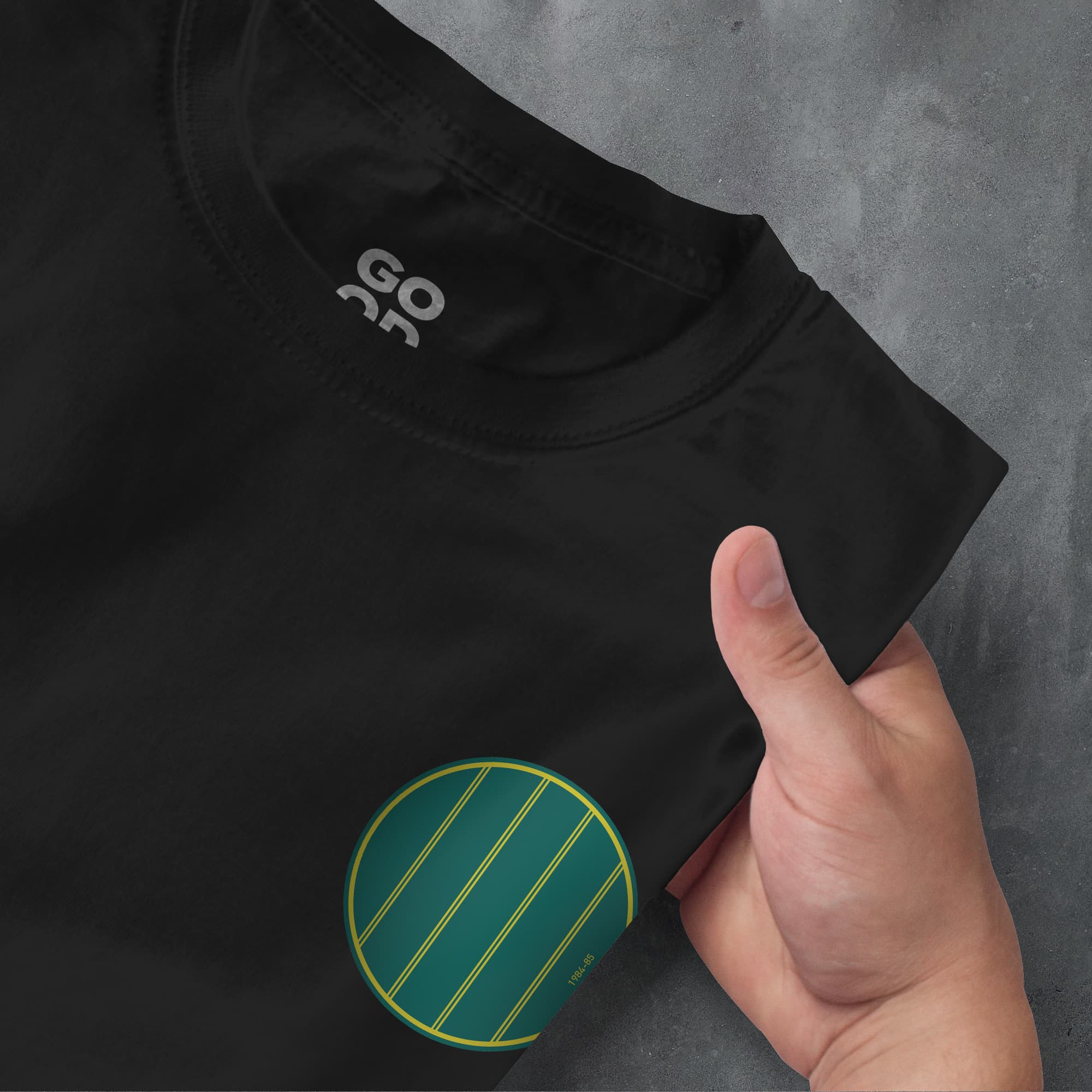a person pointing at a black shirt with a green circle on it