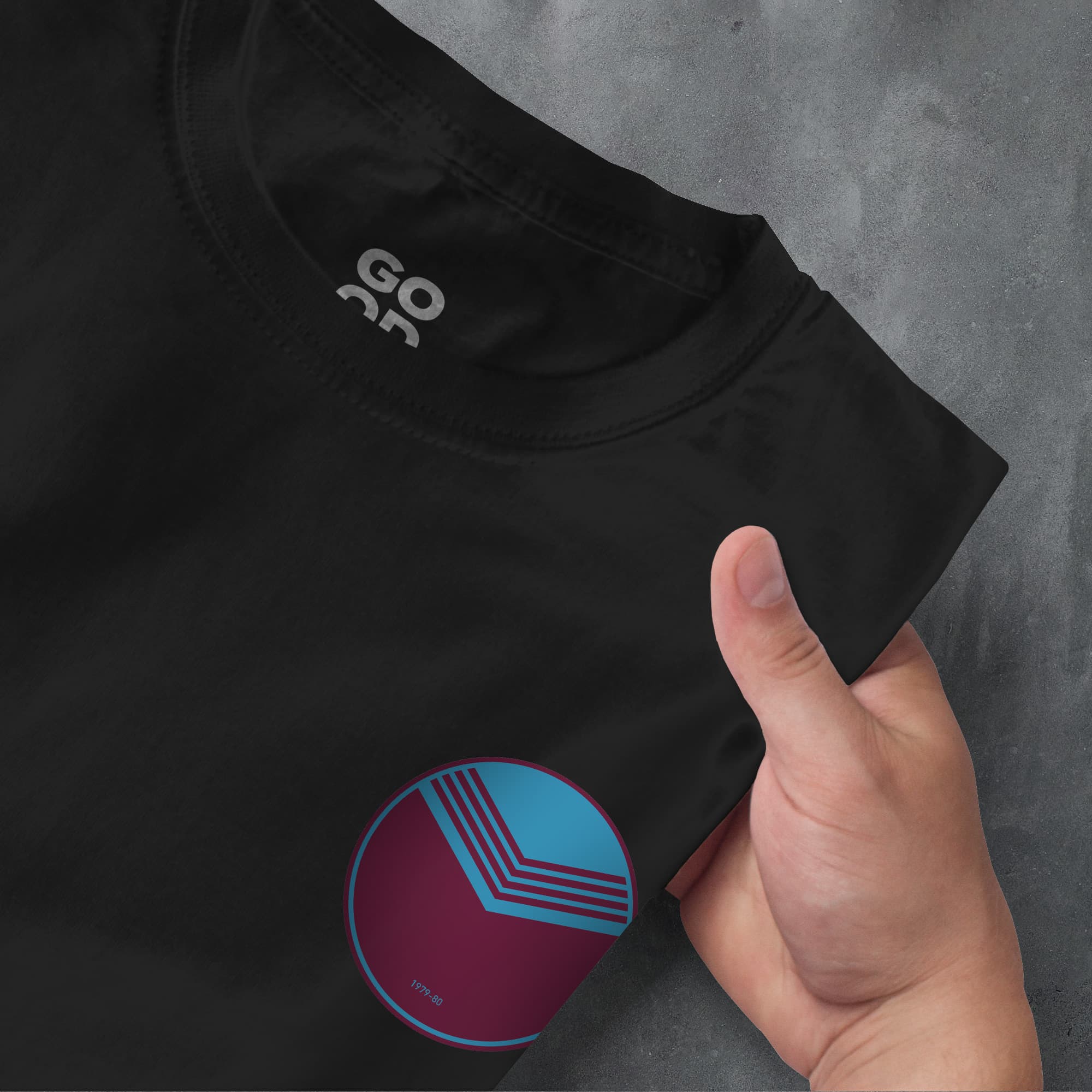 a person's hand pointing at a t - shirt with the word go as