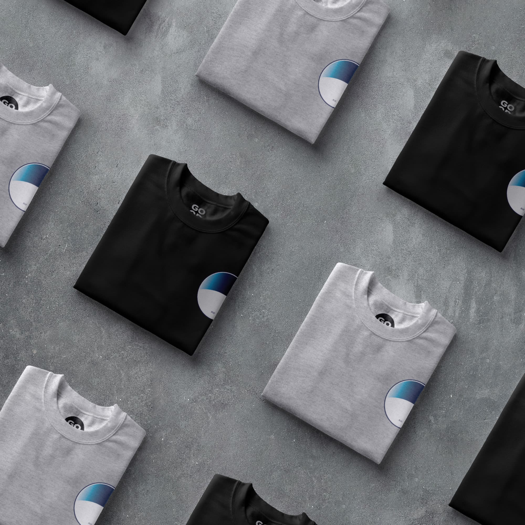 a group of t - shirts sitting on top of a cement floor