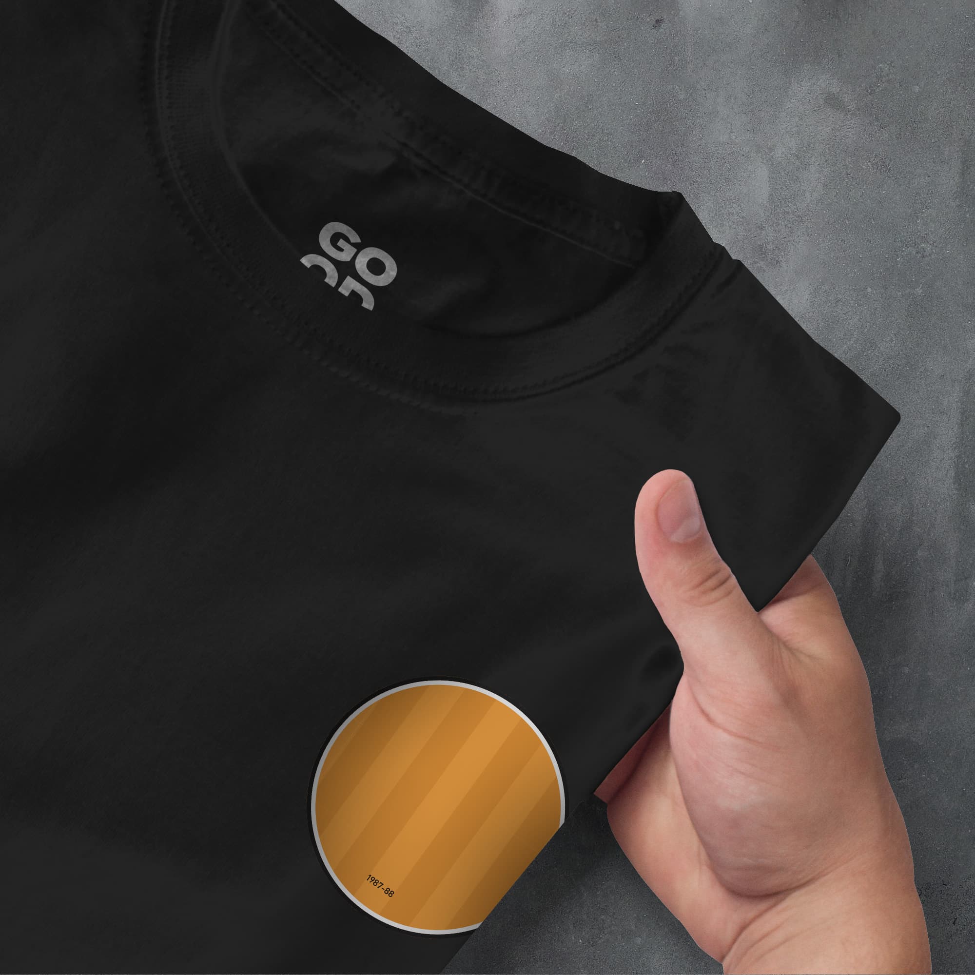 a person's hand pointing at a t - shirt with the word go as