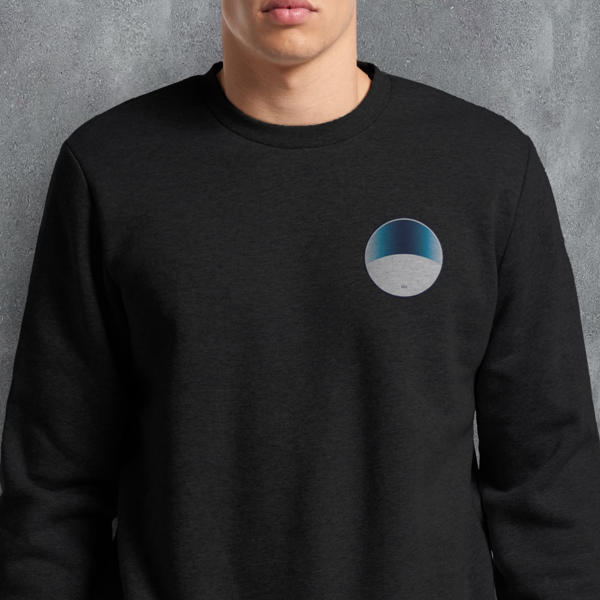 a man wearing a black sweatshirt with a blue and white circle on it