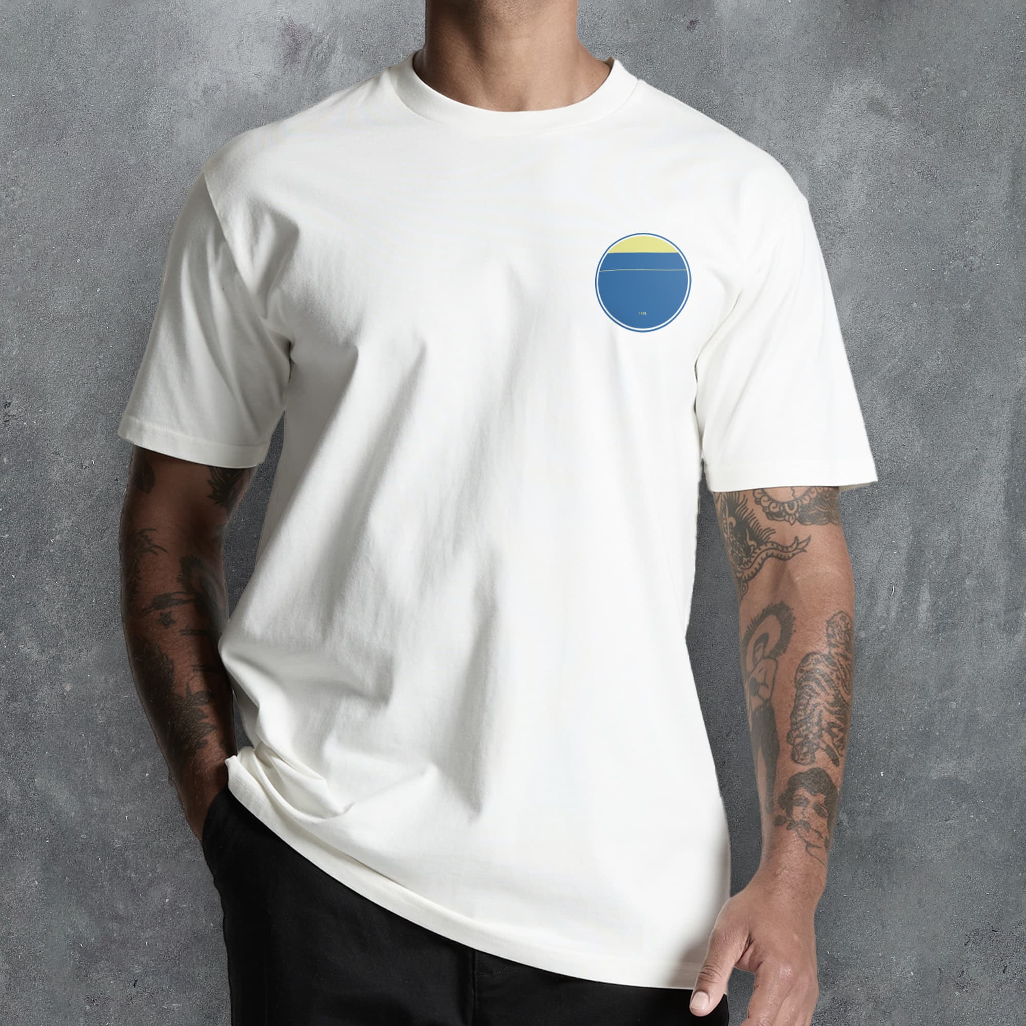 a man wearing a white t - shirt with a blue and yellow circle on the