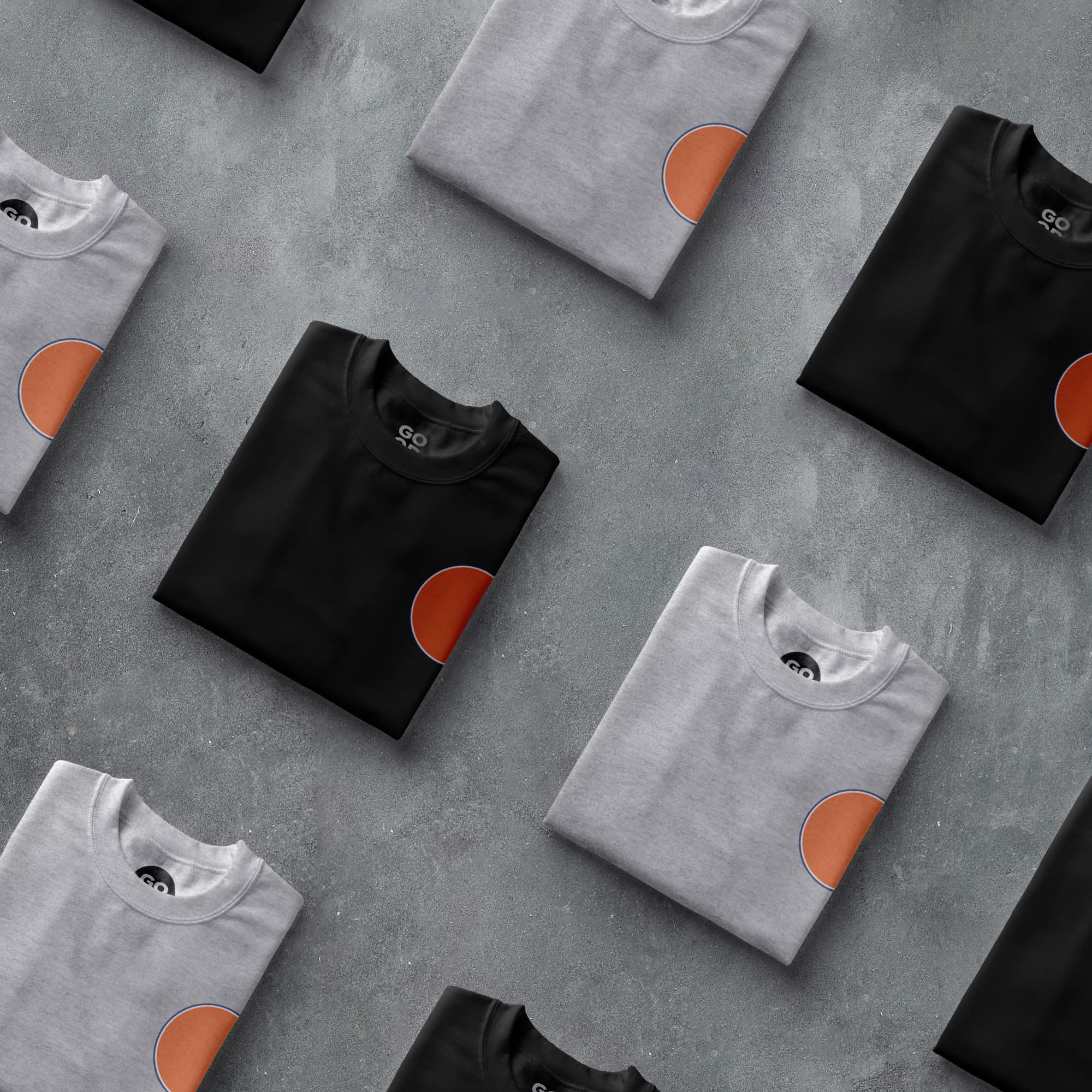 a group of black and grey t - shirts with orange circles on them