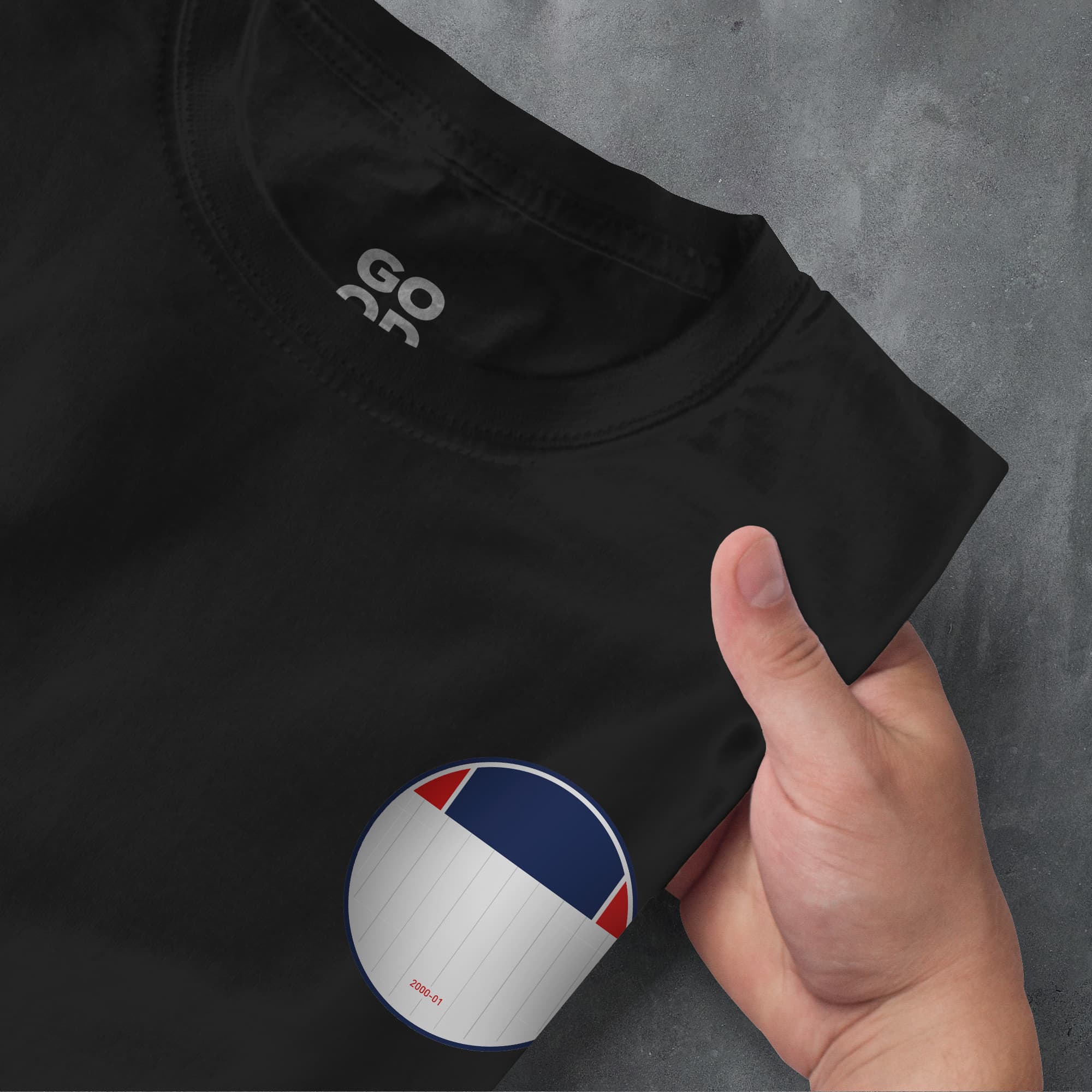 a person's hand pointing at a black t - shirt with a red,