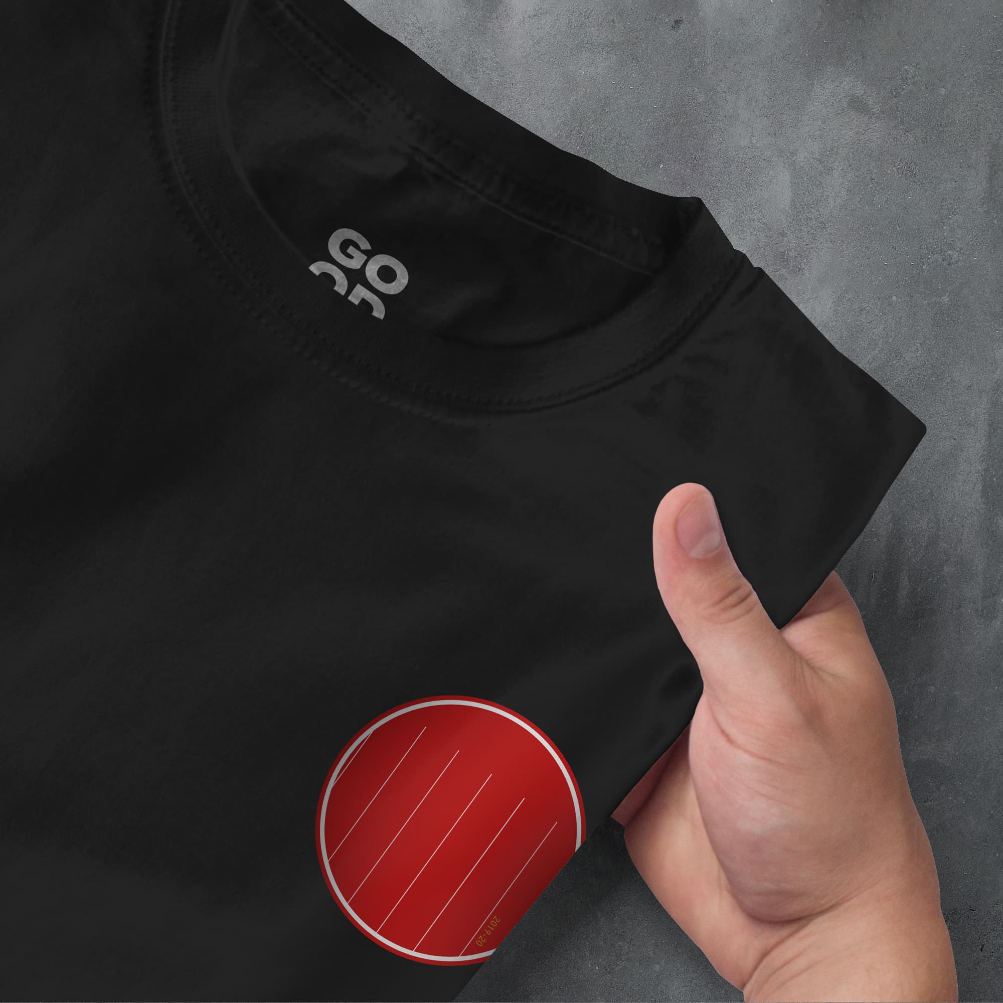 a hand pointing at a black shirt with a red circle on it