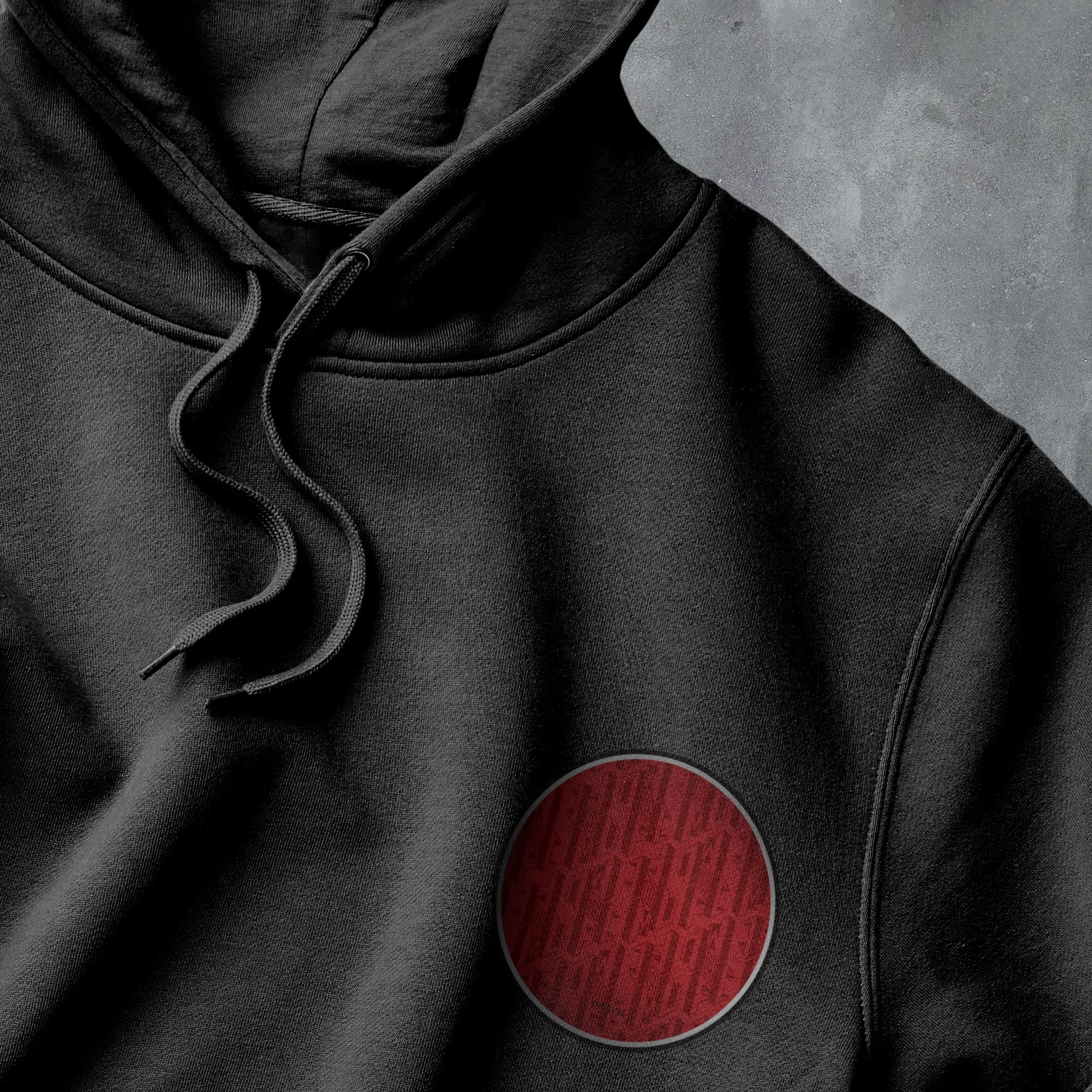 a black hoodie with a red circle on it