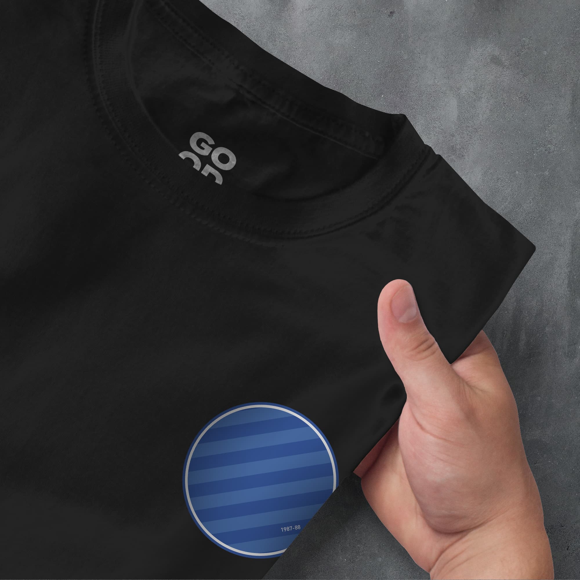 a person pointing at a black shirt with a blue circle on it