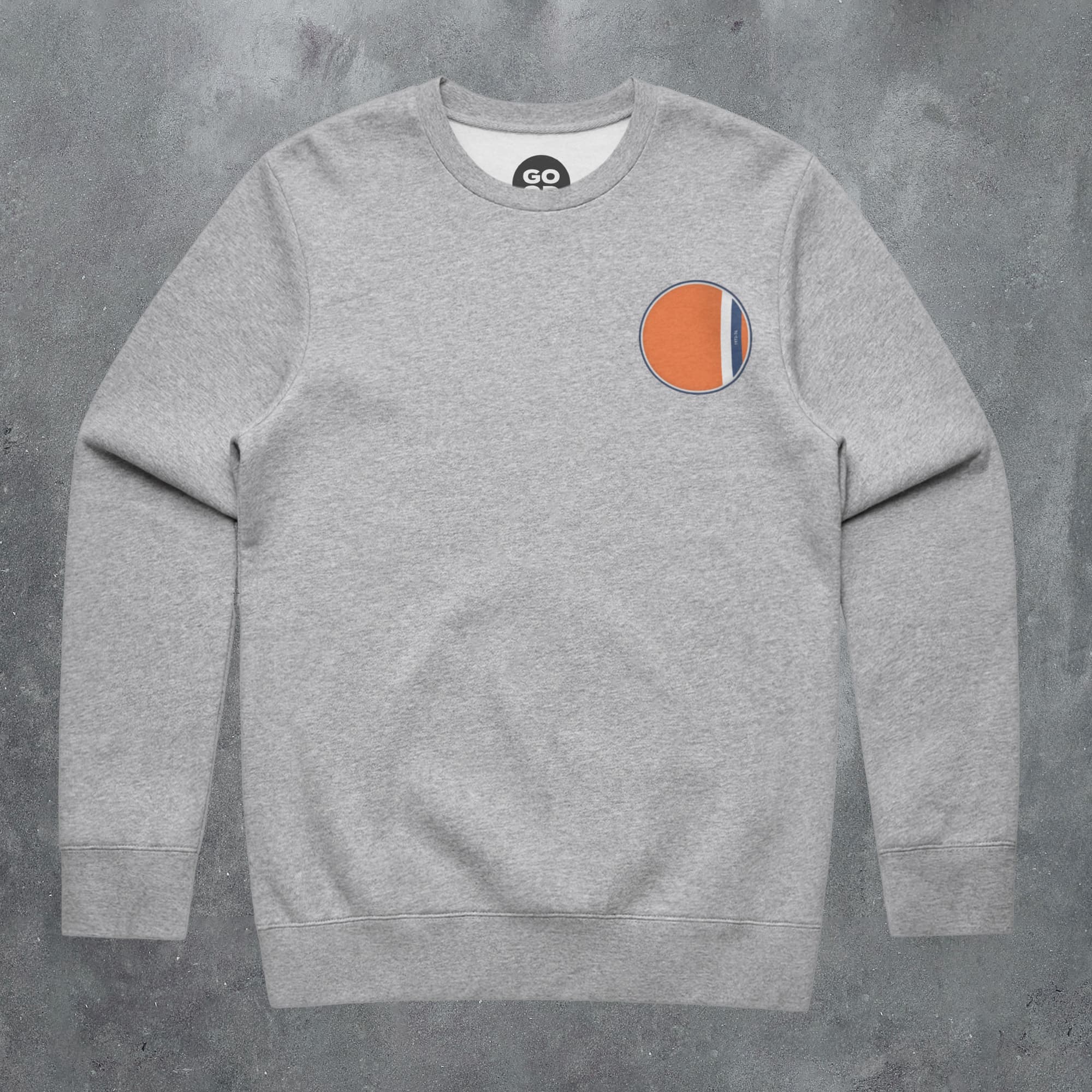a grey sweatshirt with an orange circle on the chest