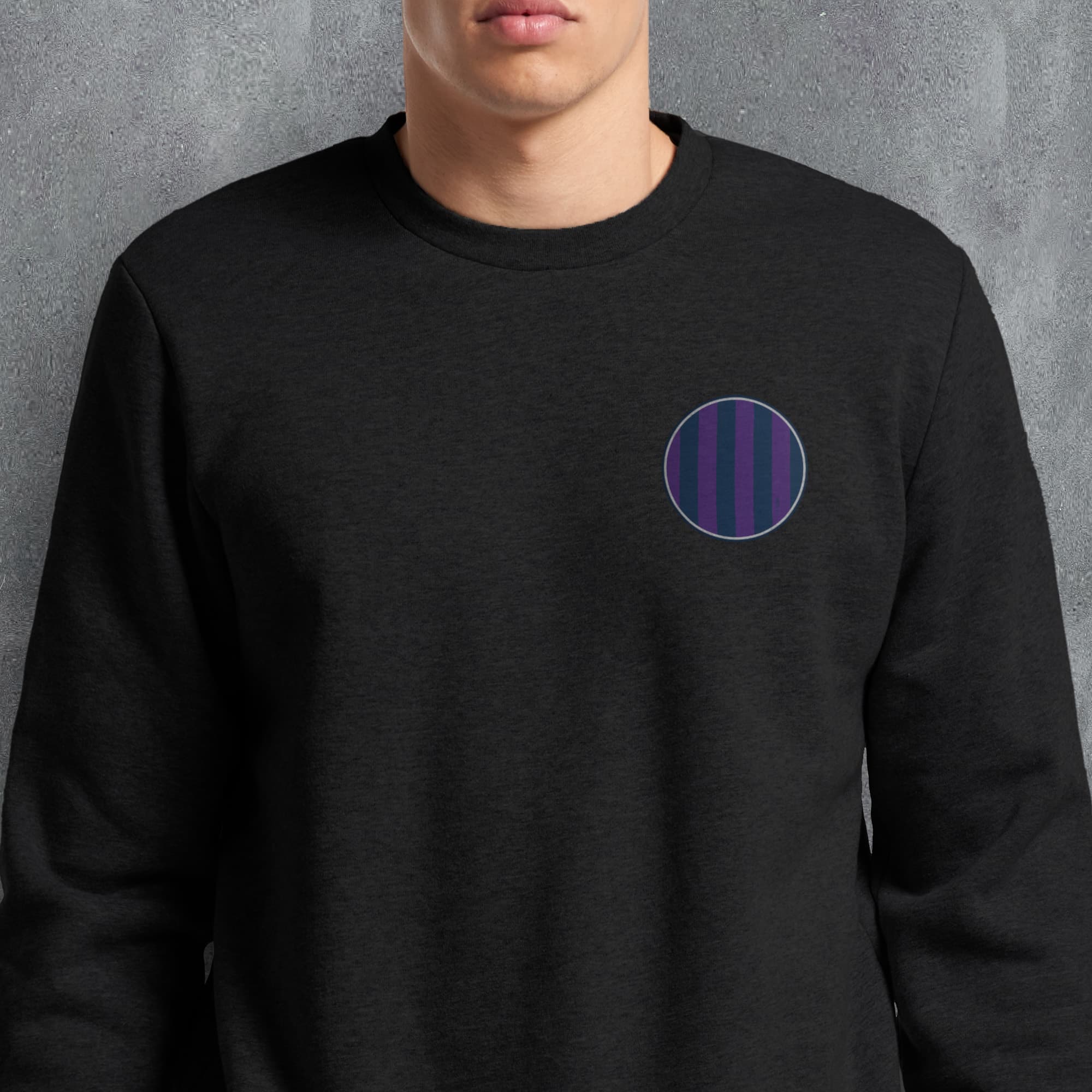 a man wearing a black sweatshirt with a purple circle on it