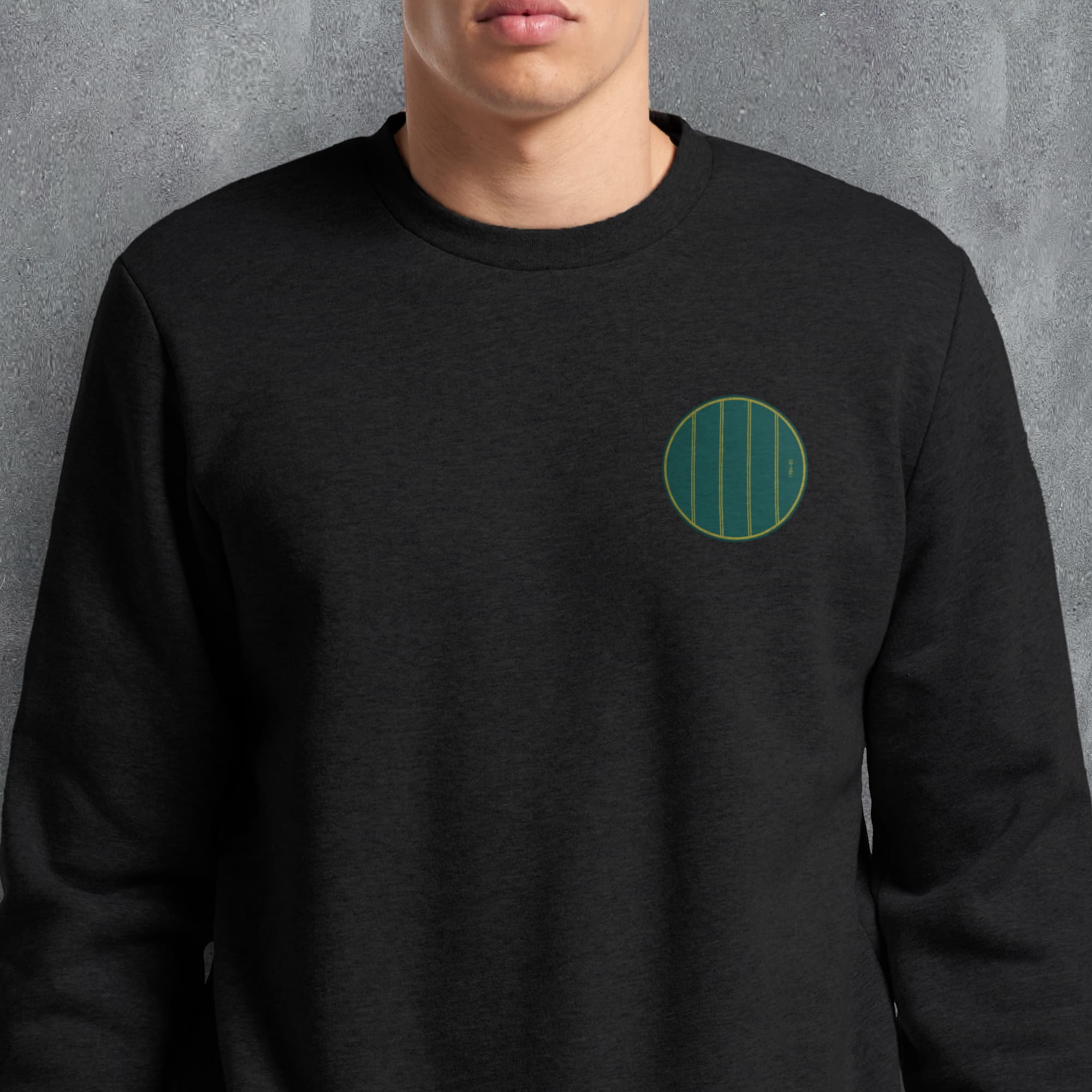 a man wearing a black sweatshirt with a green circle on it