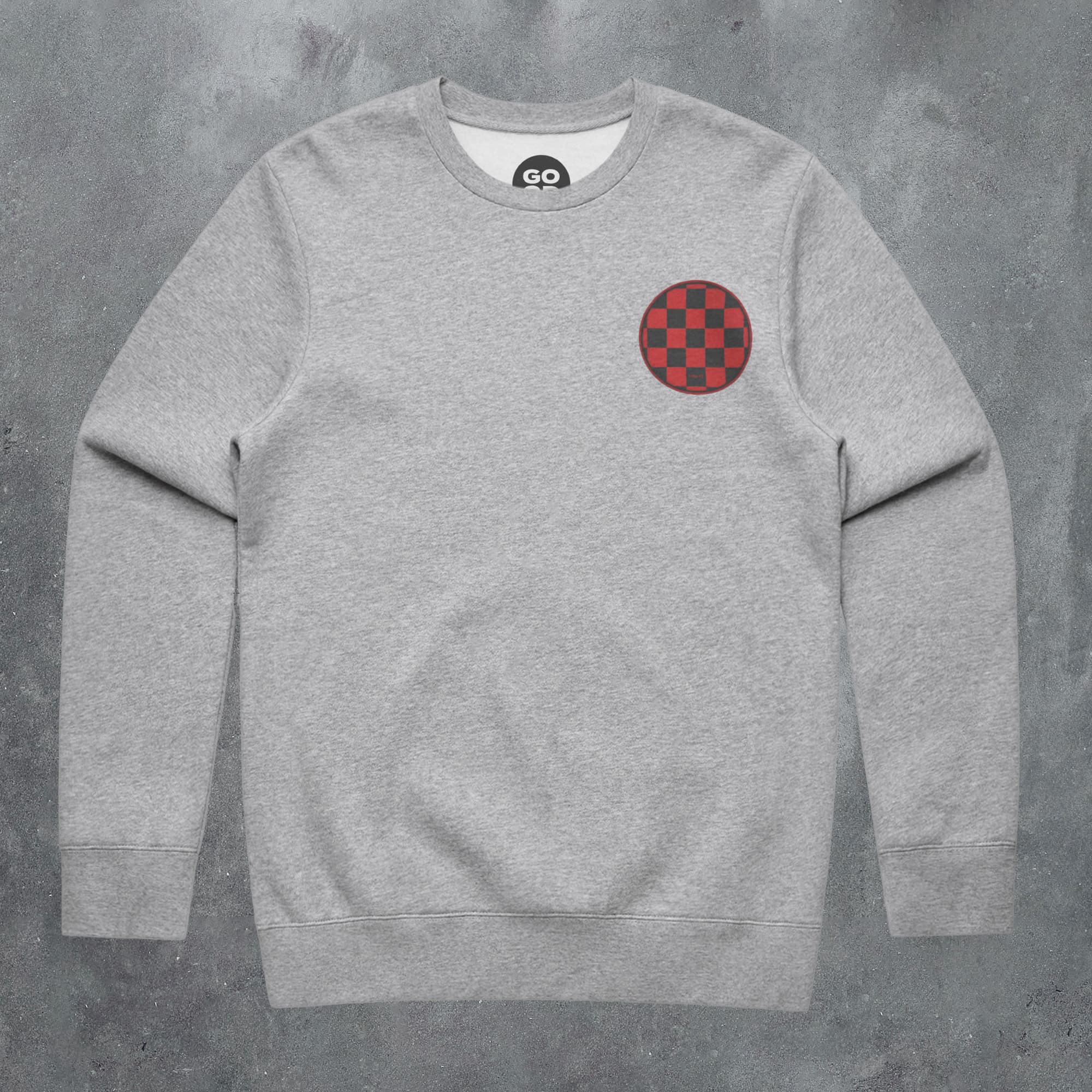 a grey sweatshirt with a red and black checkered patch on the chest