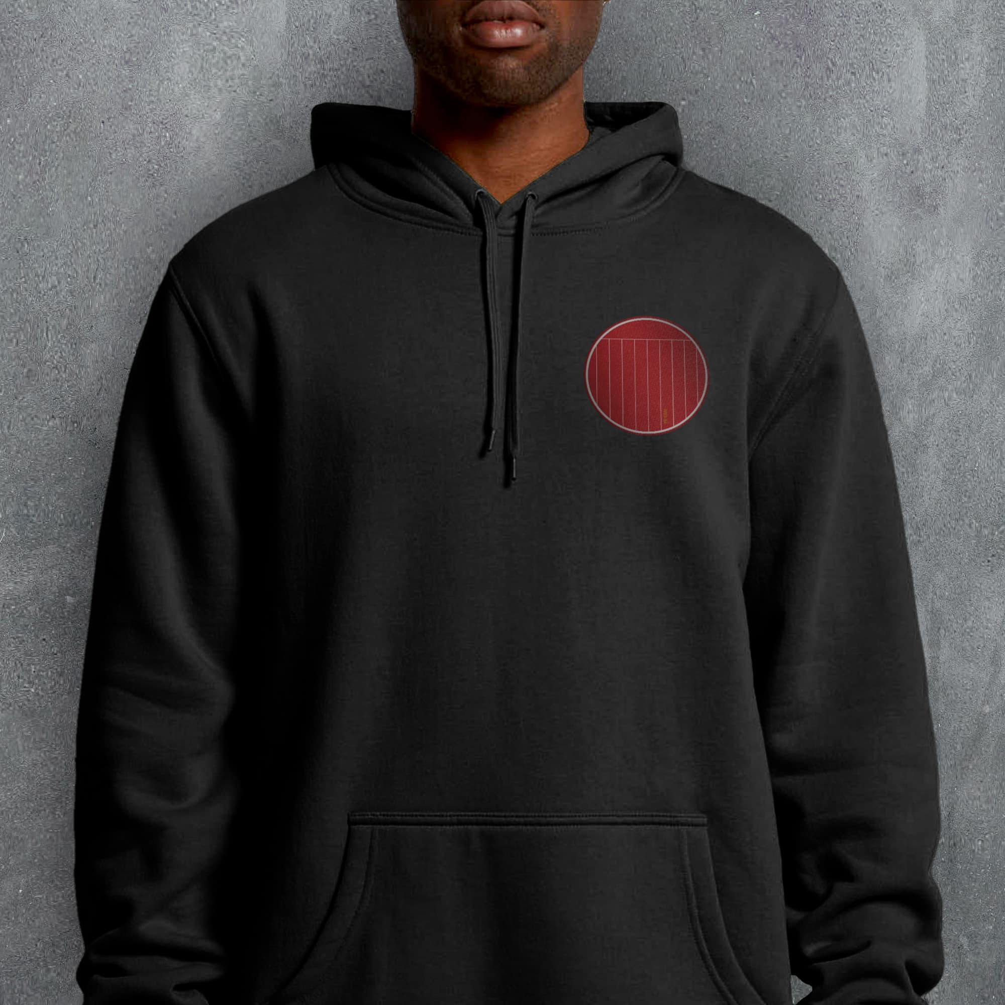 a man wearing a black hoodie with a red circle on it