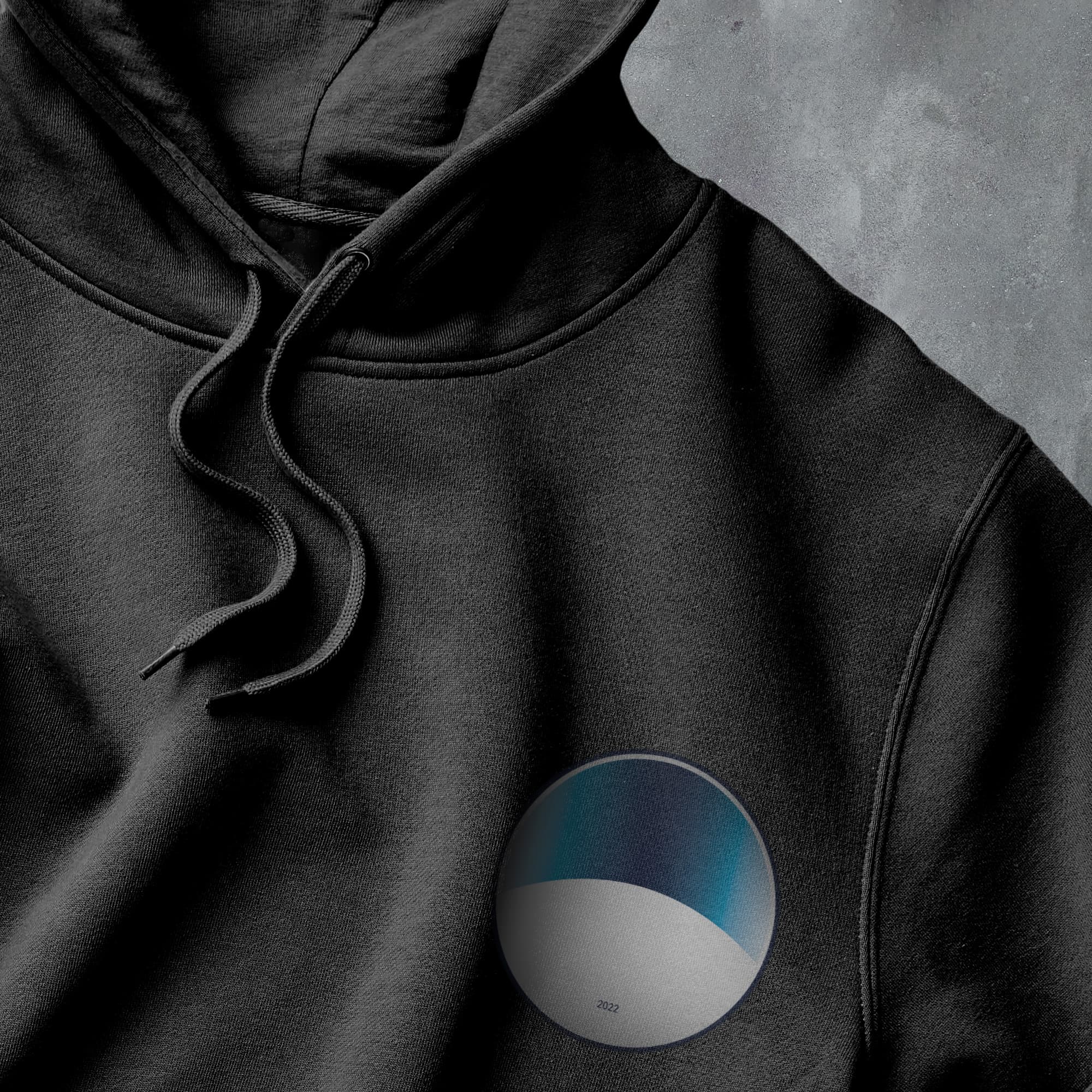 a black hoodie with a blue and white circle on it