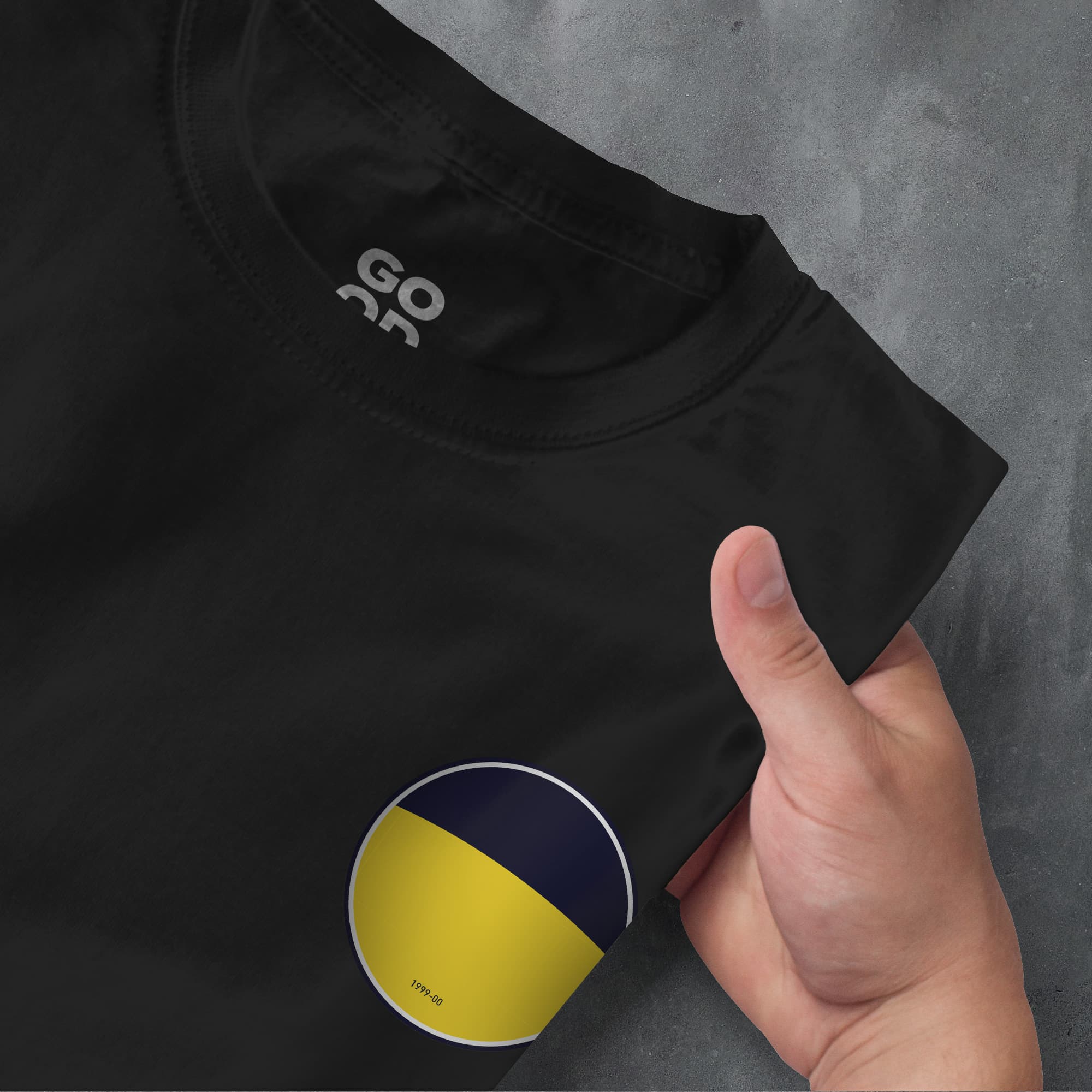 a person's hand pointing at a t - shirt with the flag of ukraine