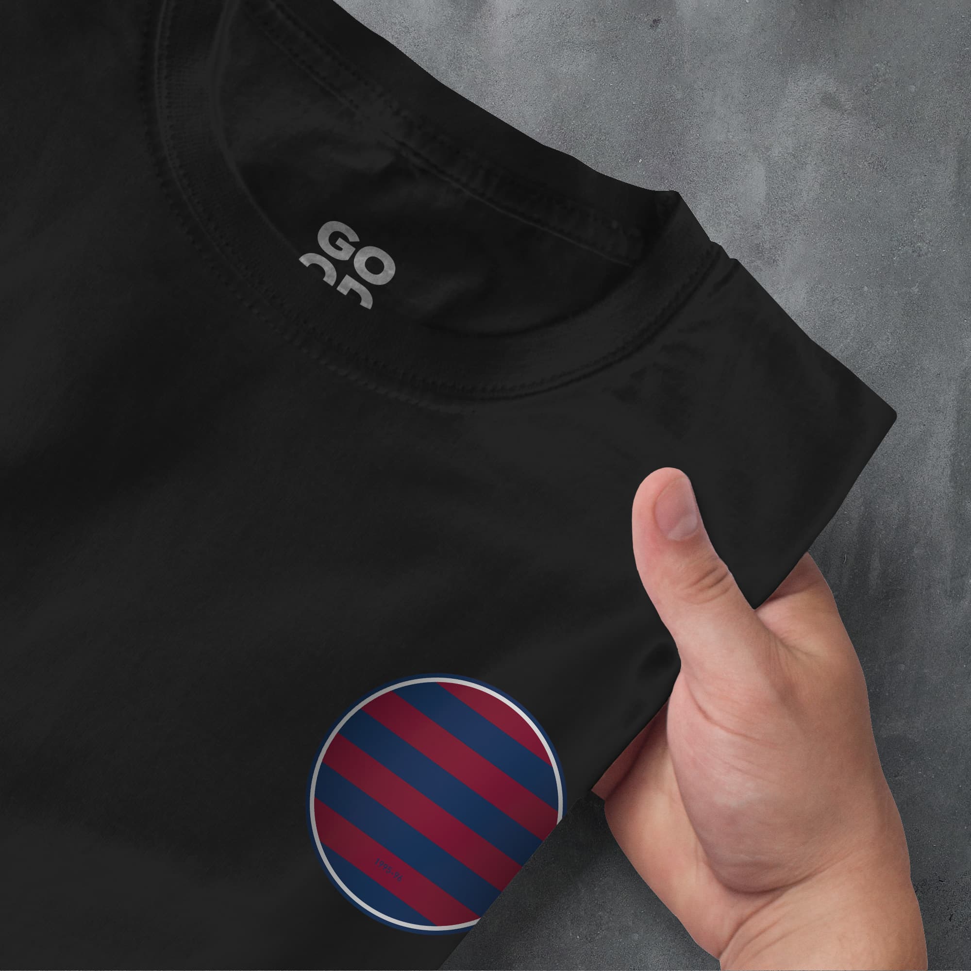 a hand pointing at a black shirt with red and blue stripes
