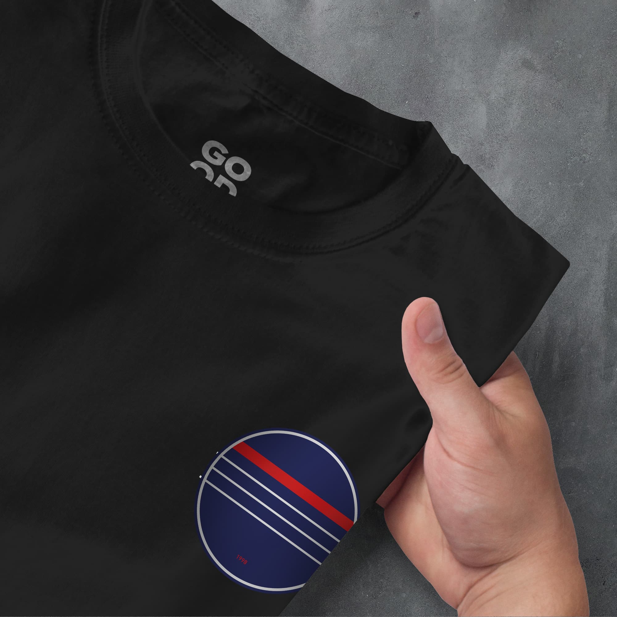 a hand pointing at a black shirt with red and blue stripes